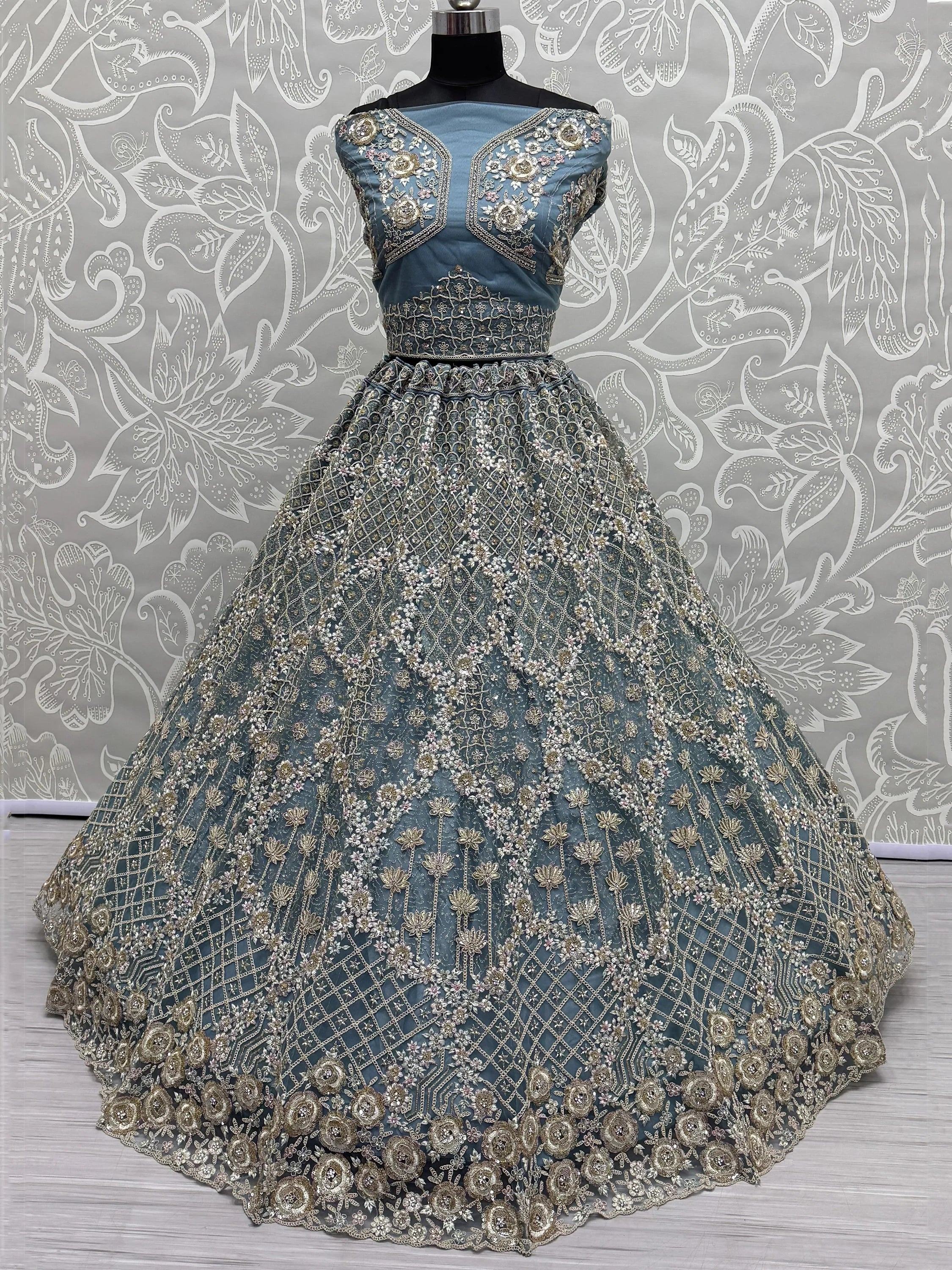 Dusty blue designer lehenga choli with heavy gold floral embroidery and net skirt, perfect for weddings.