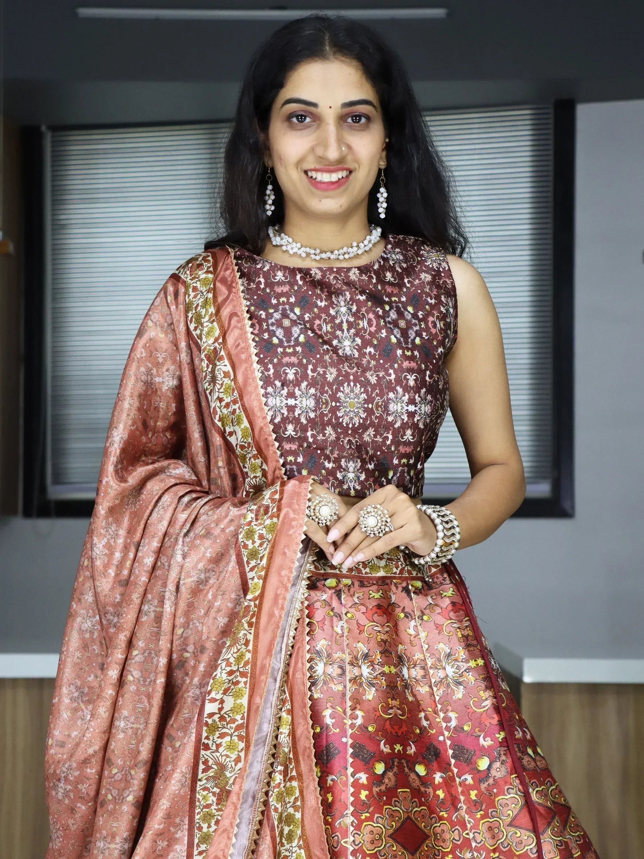 Woman in elegant Indian ethnic wear with floral print lehenga choli and dupatta, perfect for festive occasions.