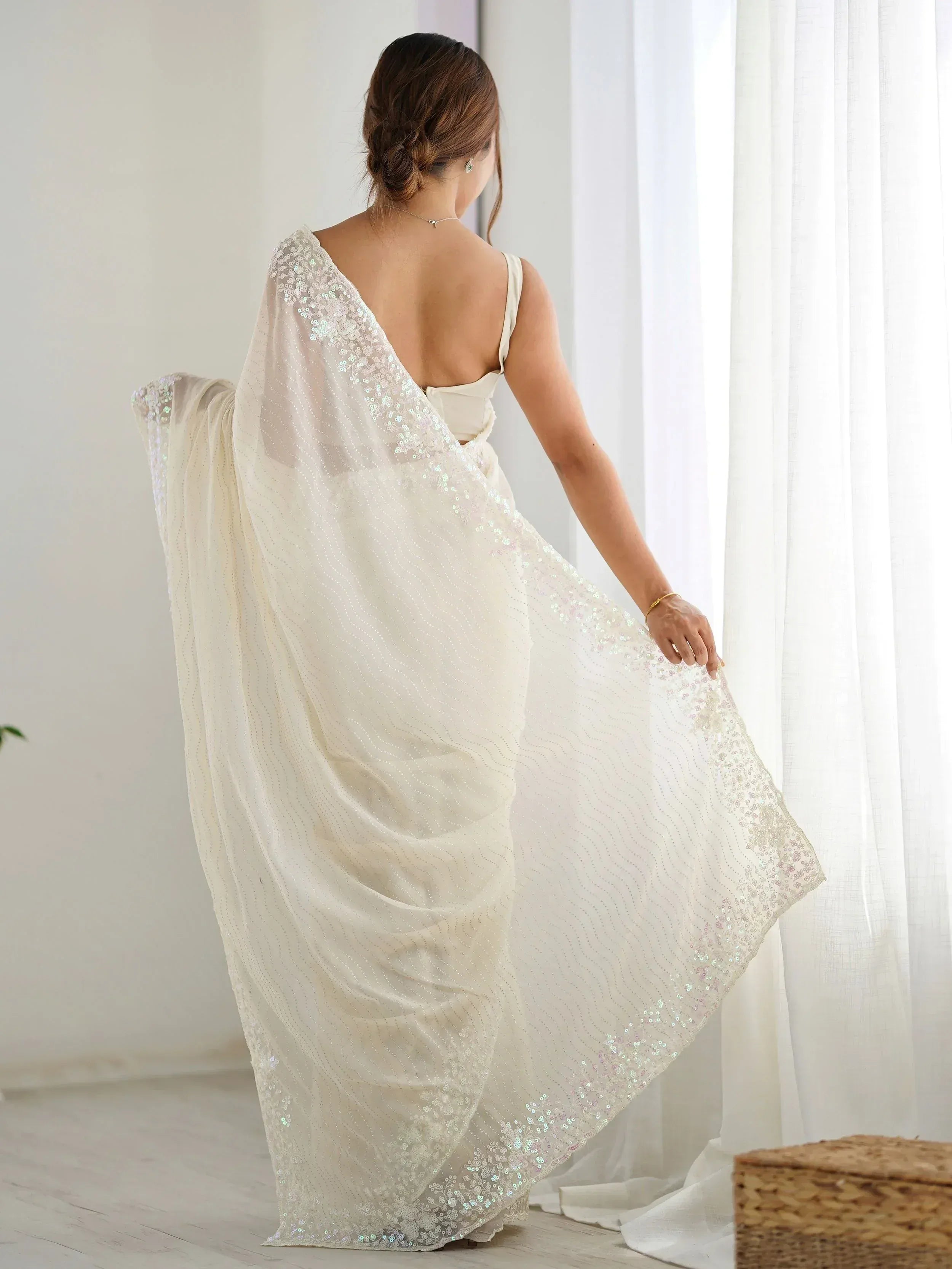 Elegant white sequined saree with sheer drape, perfect for Indian ethnic wear occasions.