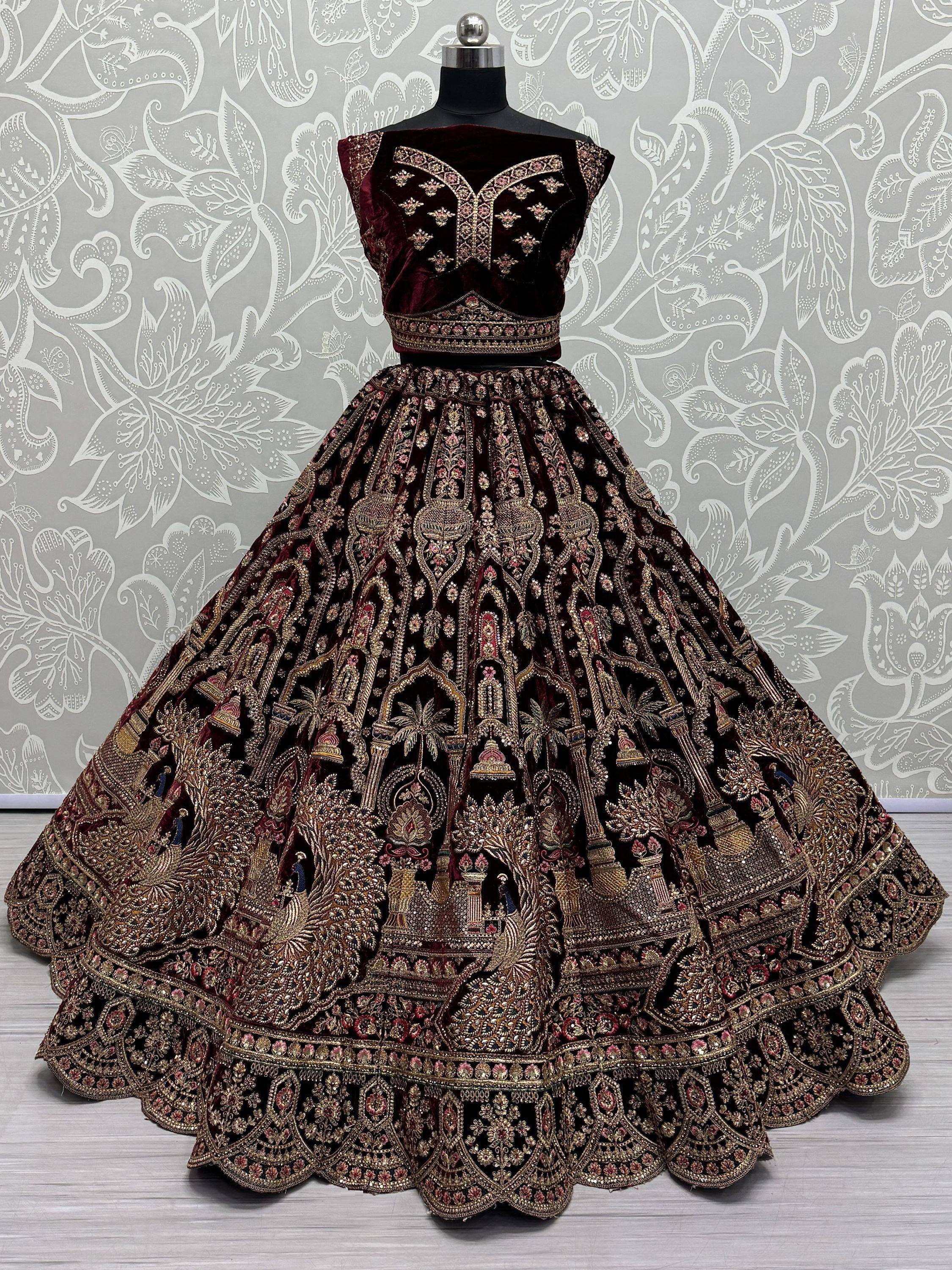 Luxury maroon velvet lehenga choli with heavy gold embroidery, perfect for Indian weddings and festive occasions.