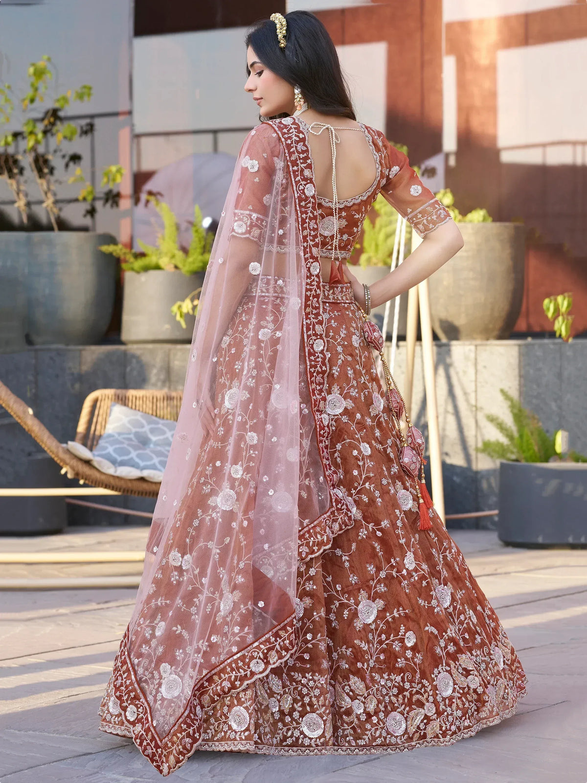 Elegant rust lehenga choli with floral embroidery and sheer dupatta, perfect for Indian weddings and festive occasions.