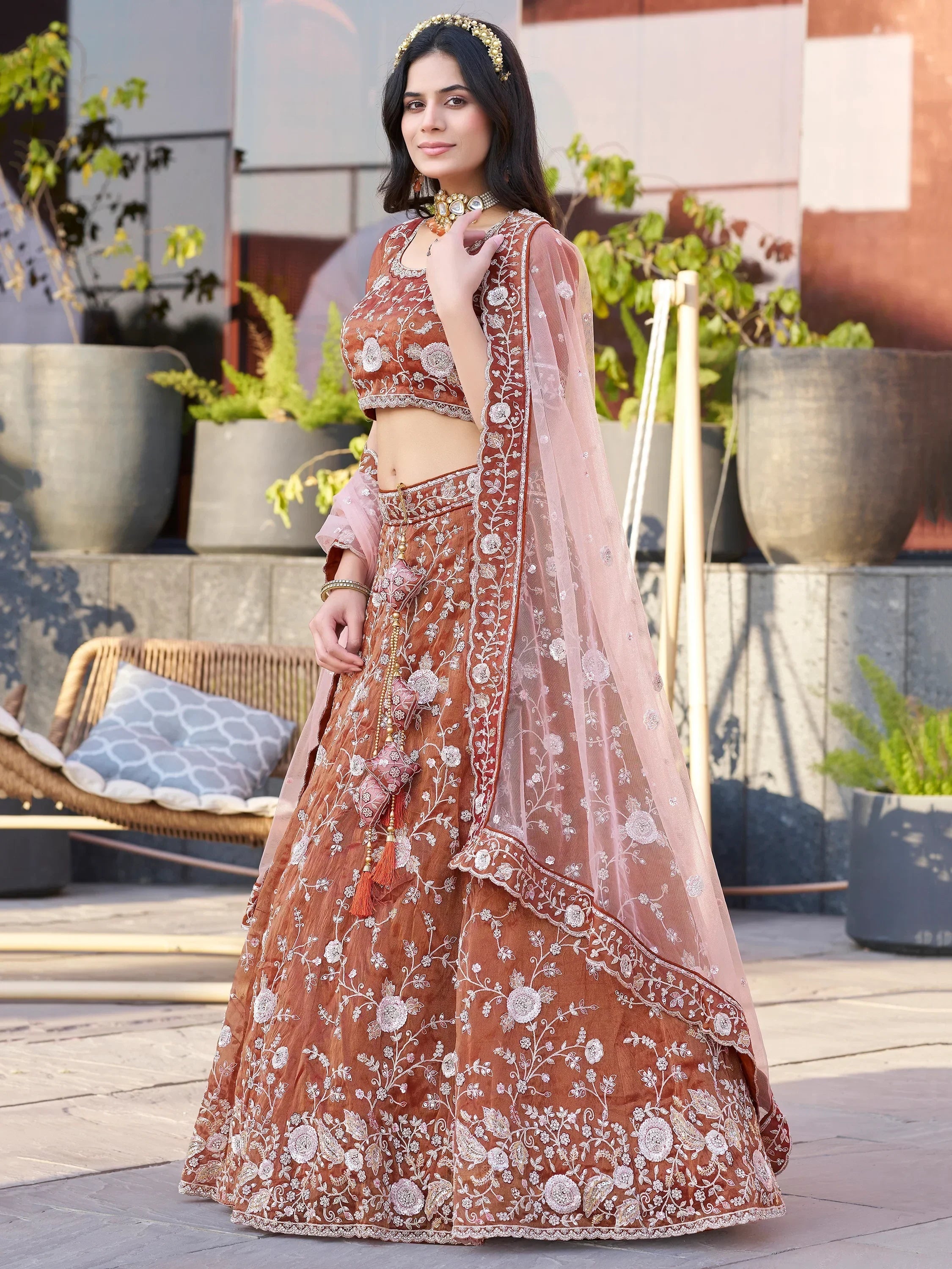 Elegant brown embroidered lehenga choli with floral motifs and sheer dupatta, perfect for Indian ethnic occasions.