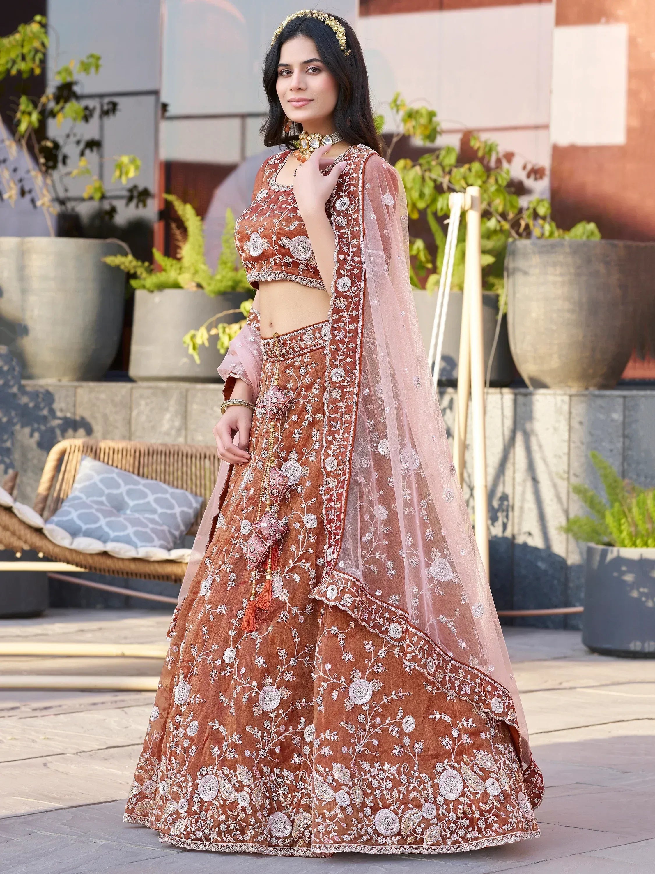 Elegant brown embroidered lehenga choli with floral motifs and sheer dupatta, perfect for Indian ethnic occasions.