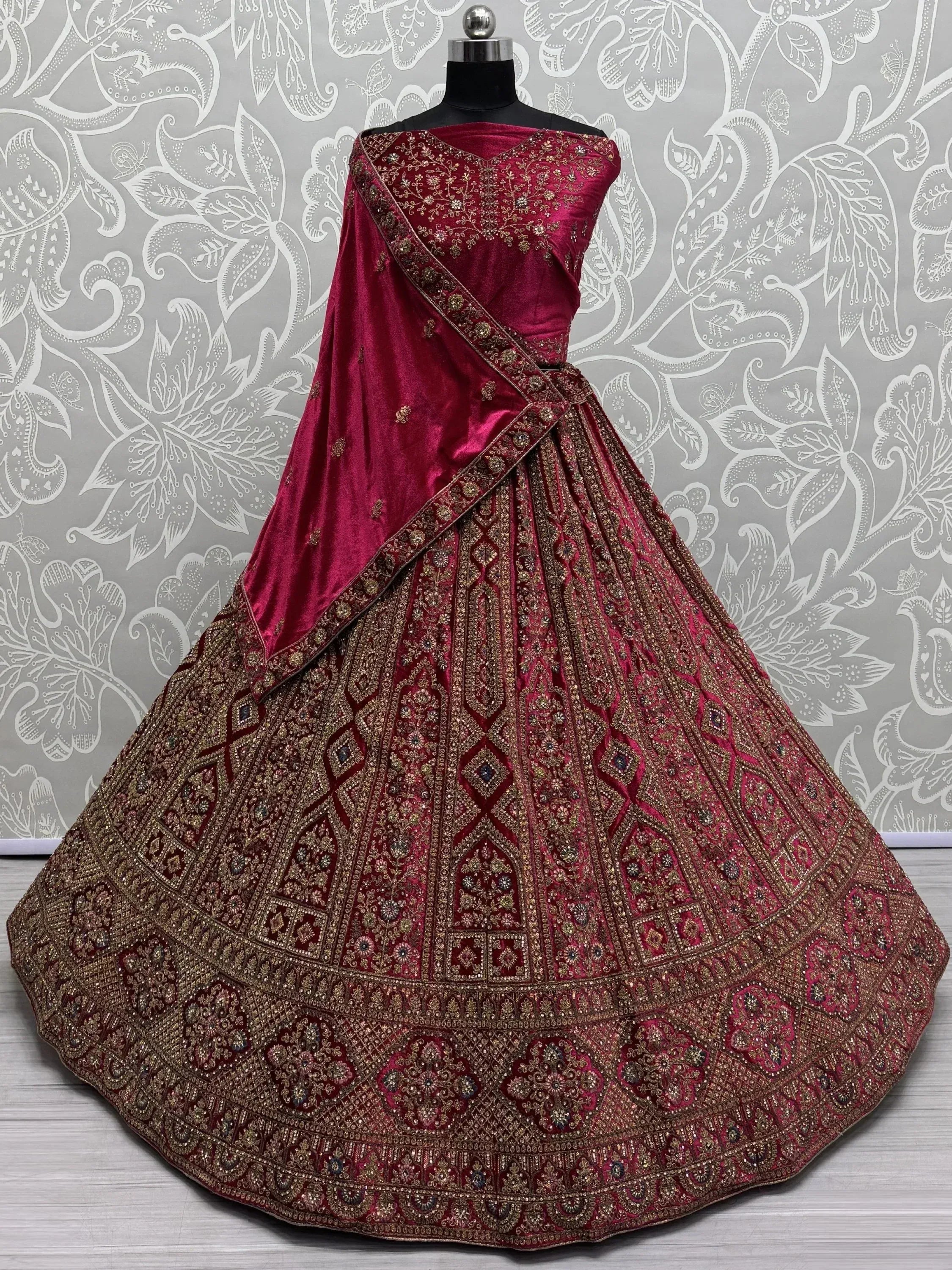 Luxury maroon velvet lehenga choli with heavy gold embroidery, perfect for weddings and festive occasions.