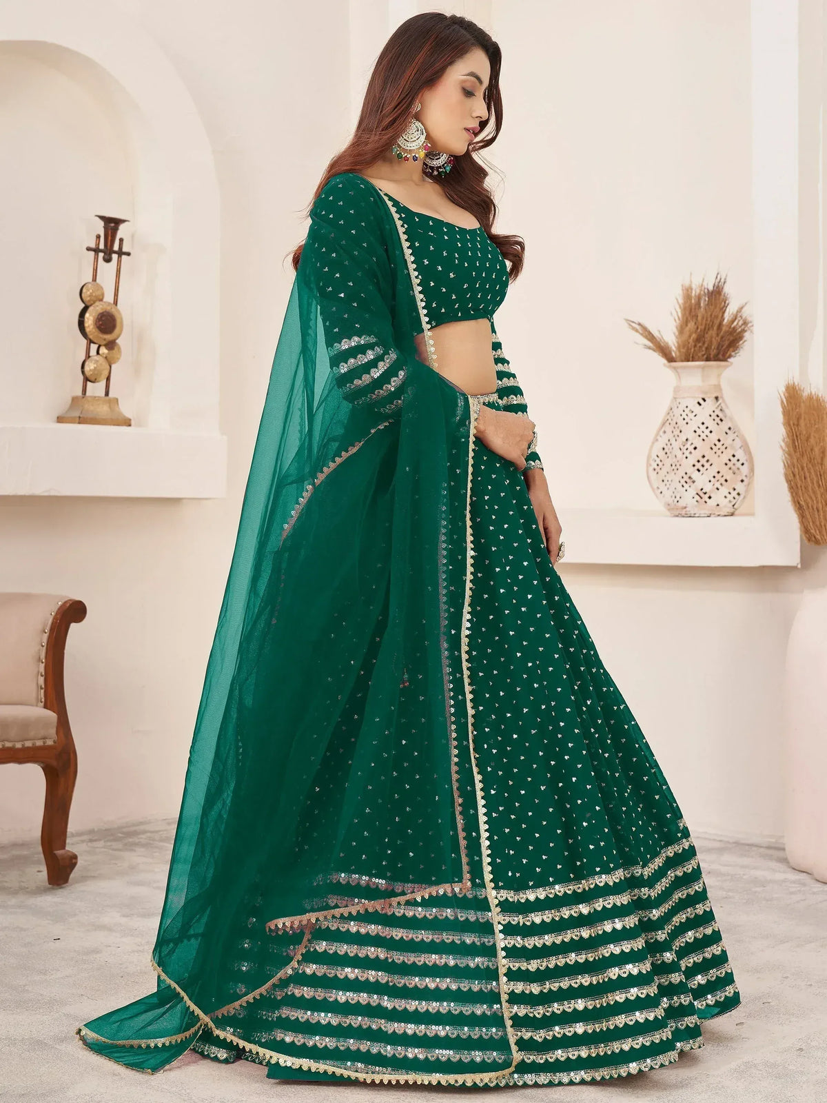 Emerald green designer lehenga choli with sequin work and gold trim, perfect for Indian weddings and festivals