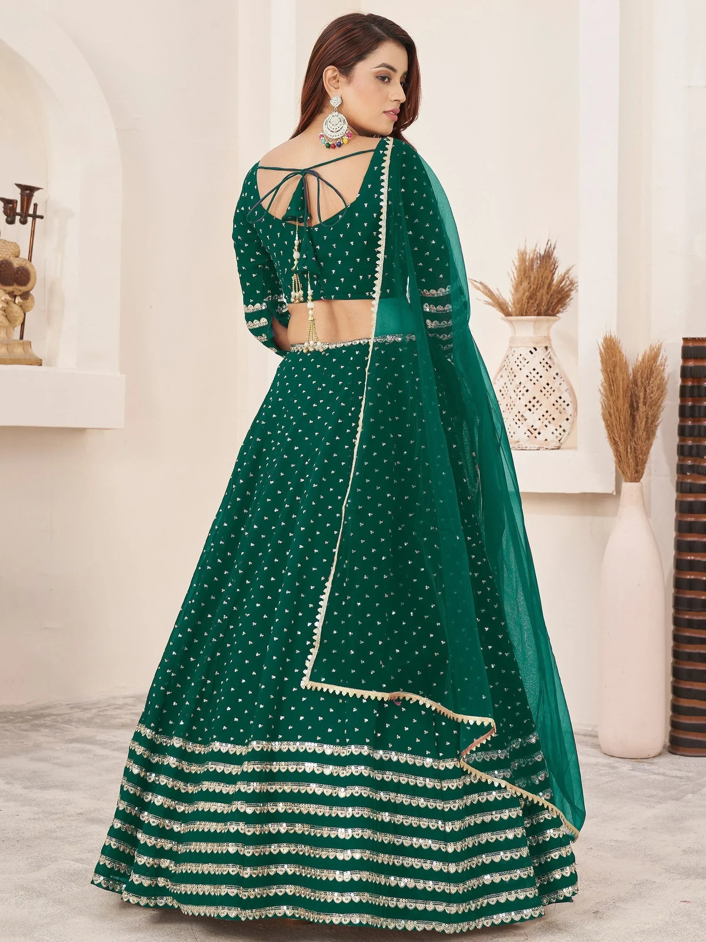 Emerald green designer lehenga choli with gold embroidery and sheer dupatta, perfect for Indian weddings