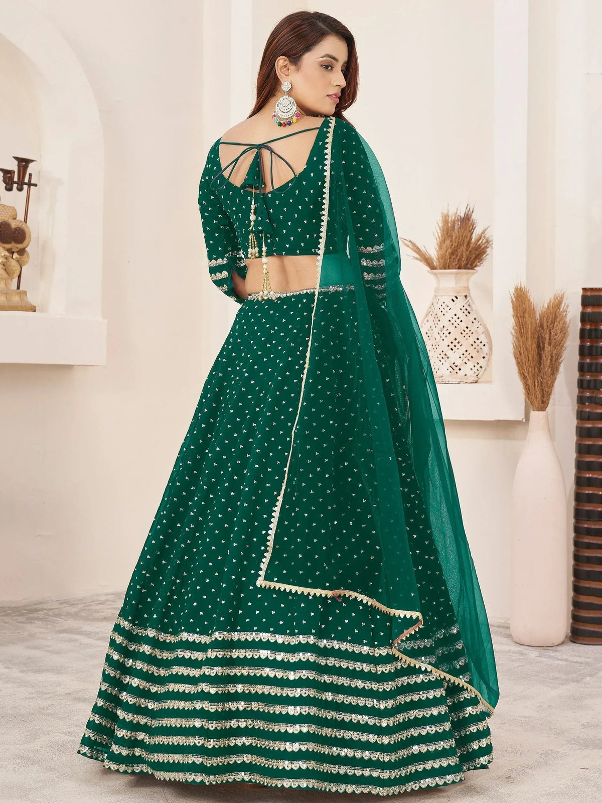 Emerald green designer lehenga choli with gold embroidery and sheer dupatta, perfect for Indian weddings