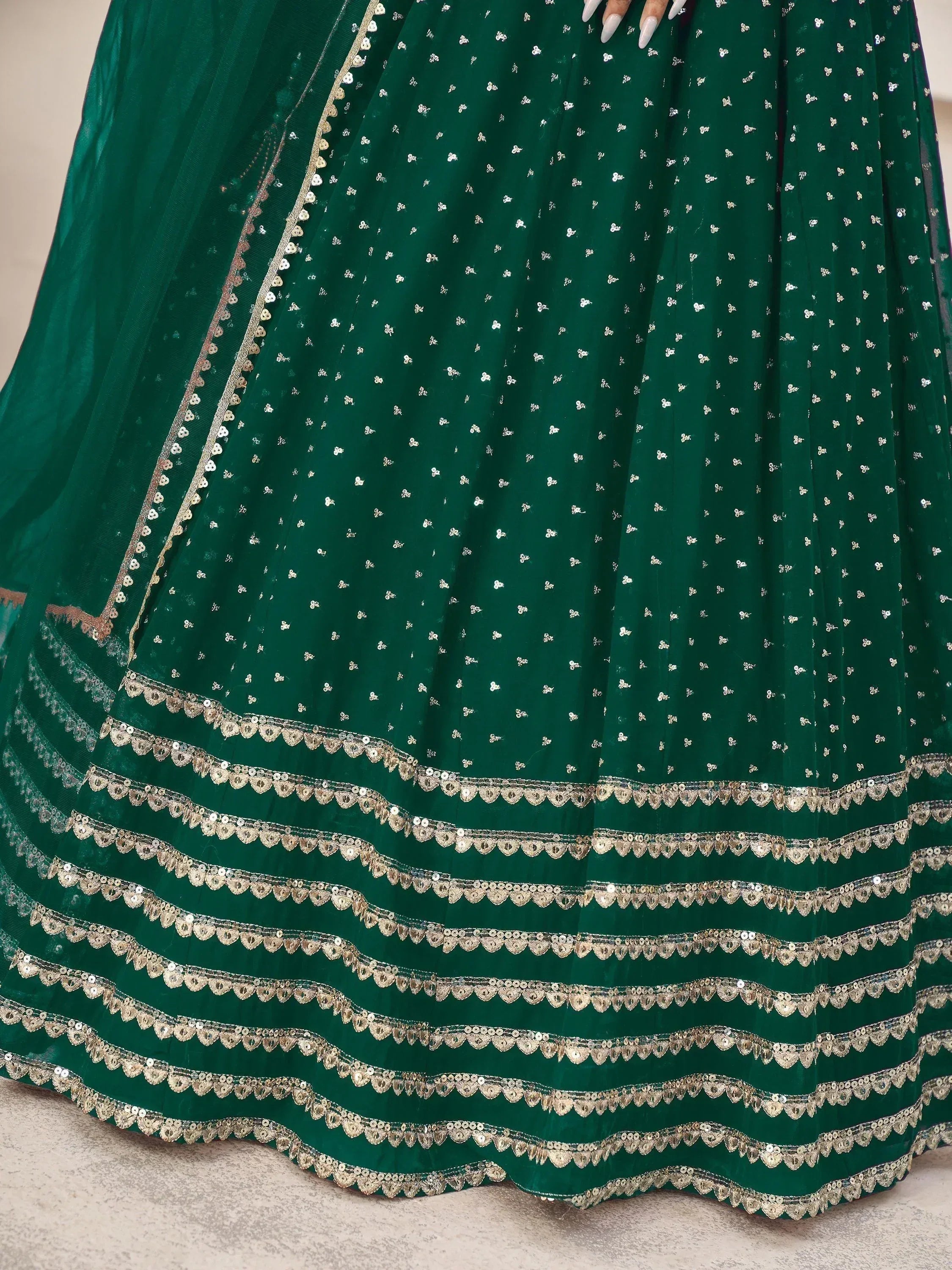 Emerald green lehenga with gold sequin embroidery and scalloped borders, ideal for Indian ethnic wear.