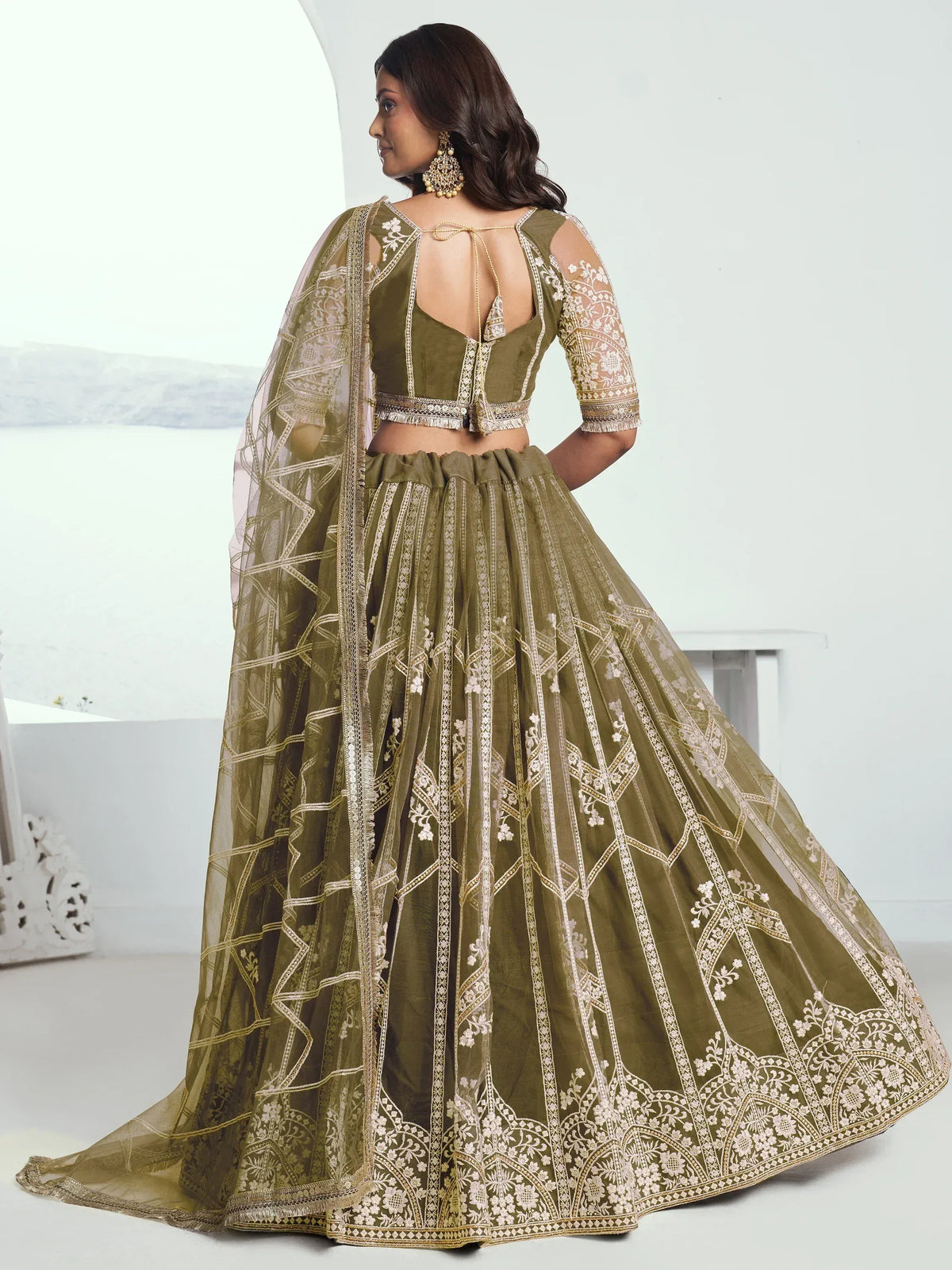 Olive green designer lehenga choli with intricate gold embroidery and sheer dupatta, perfect for weddings and festive occasions.