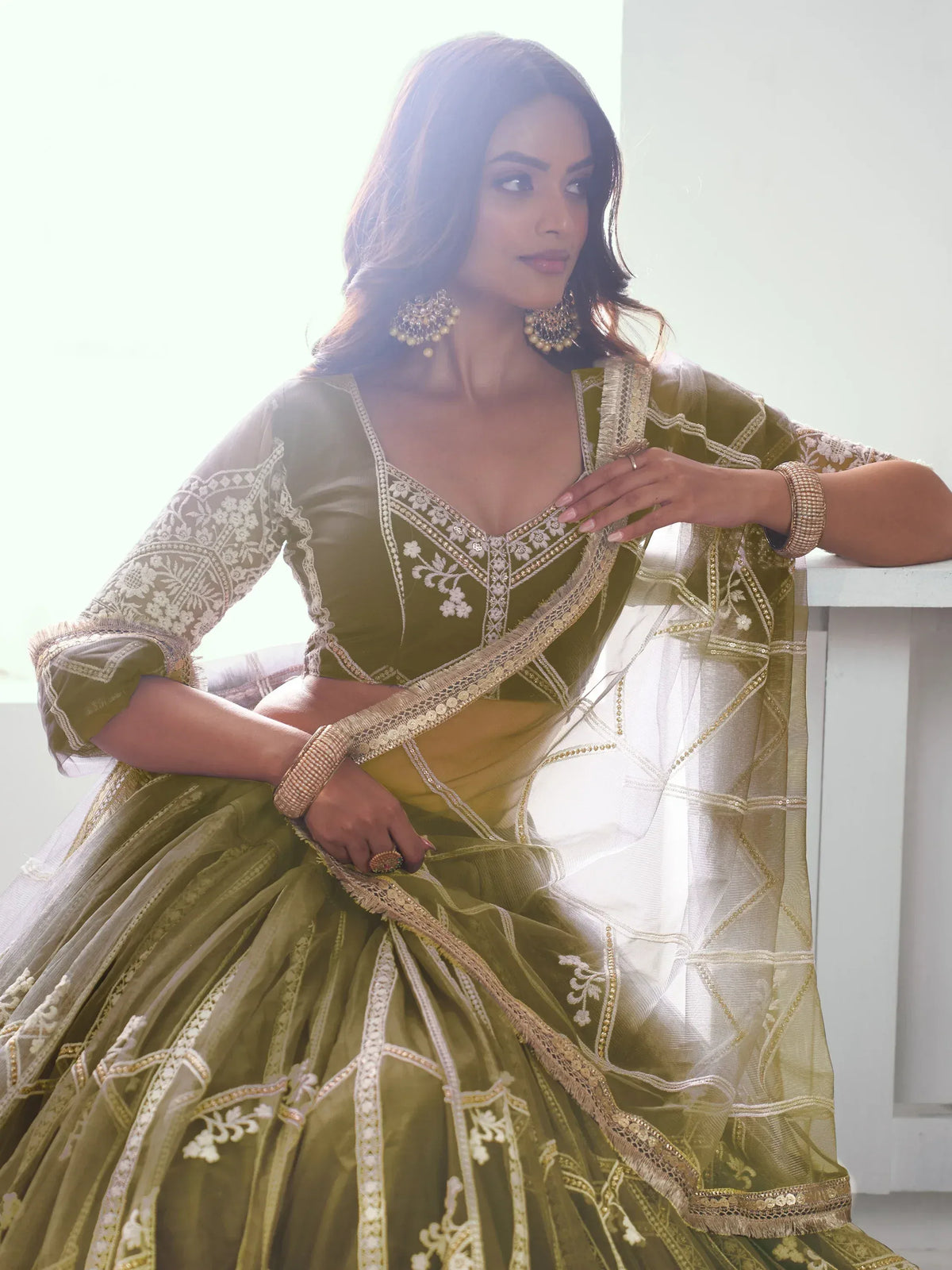 Olive green designer lehenga choli with gold embroidery and sheer dupatta, perfect for Indian ethnic wear