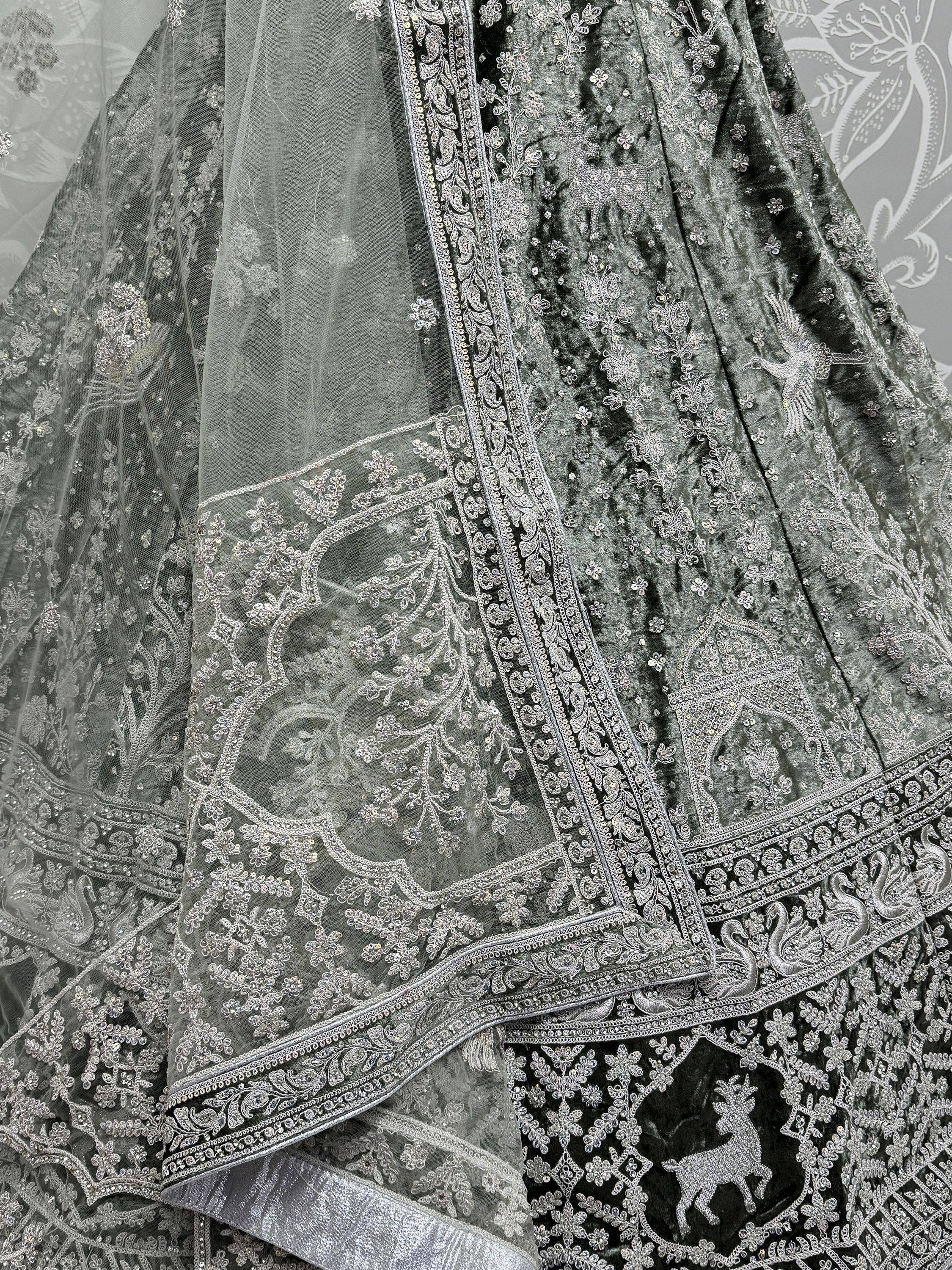 Grey velvet lehenga with silver embroidery and sheer dupatta, featuring floral and animal motifs for ethnic wear.