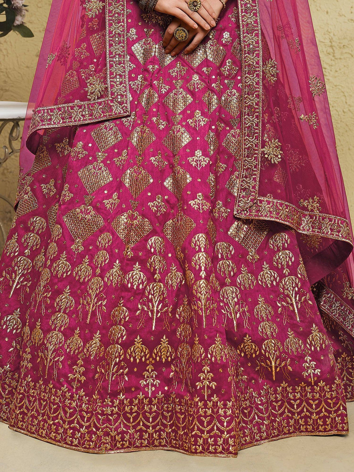 Fuchsia lehenga choli with gold embroidery, perfect for Indian weddings and festive occasions.