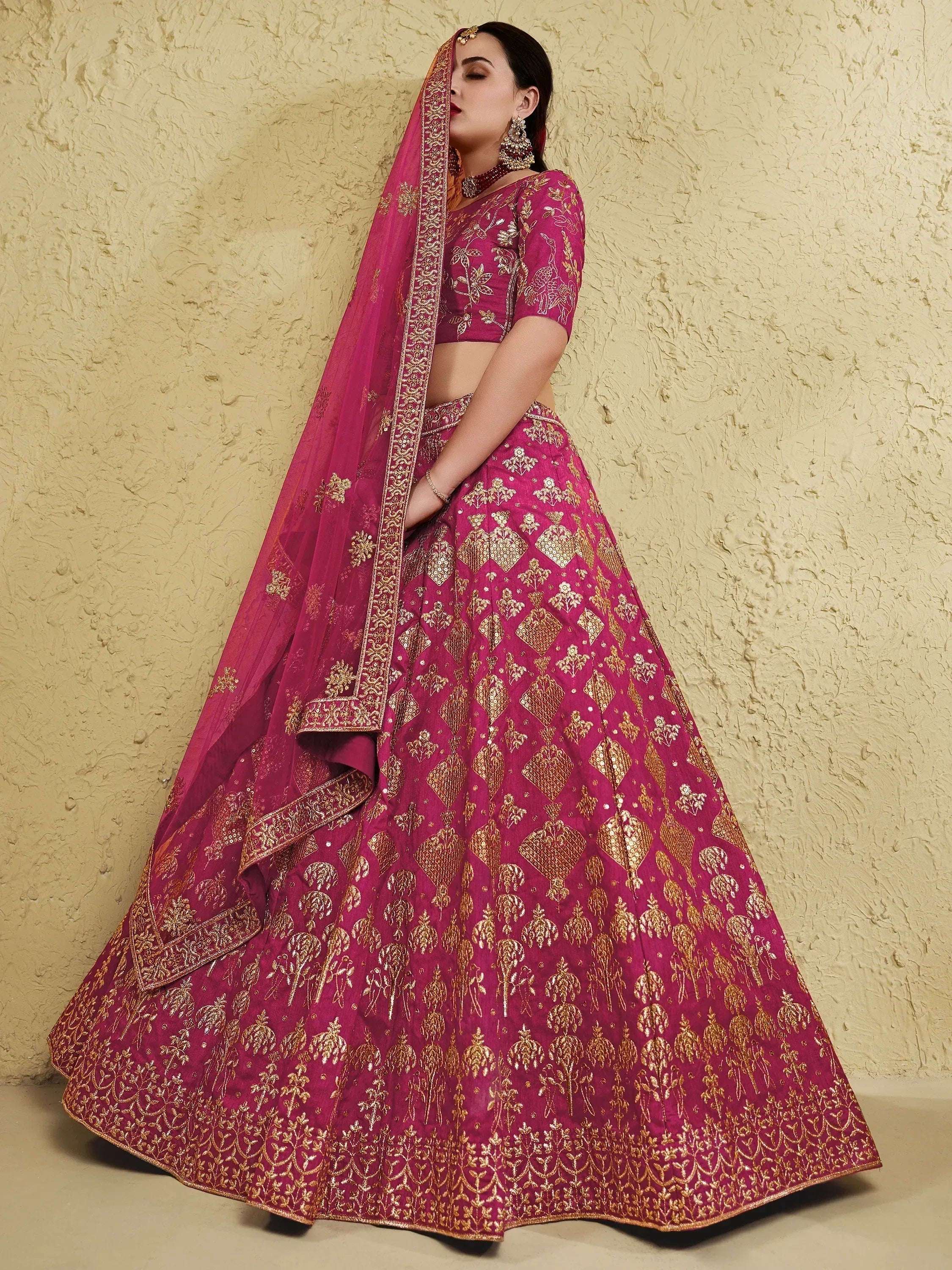 Magenta lehenga choli with gold embroidery, perfect for Indian weddings and festive occasions.