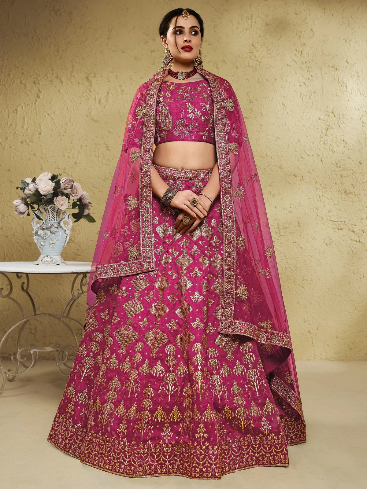 Fuchsia designer lehenga choli with gold embroidery, perfect for Indian weddings and festive occasions.