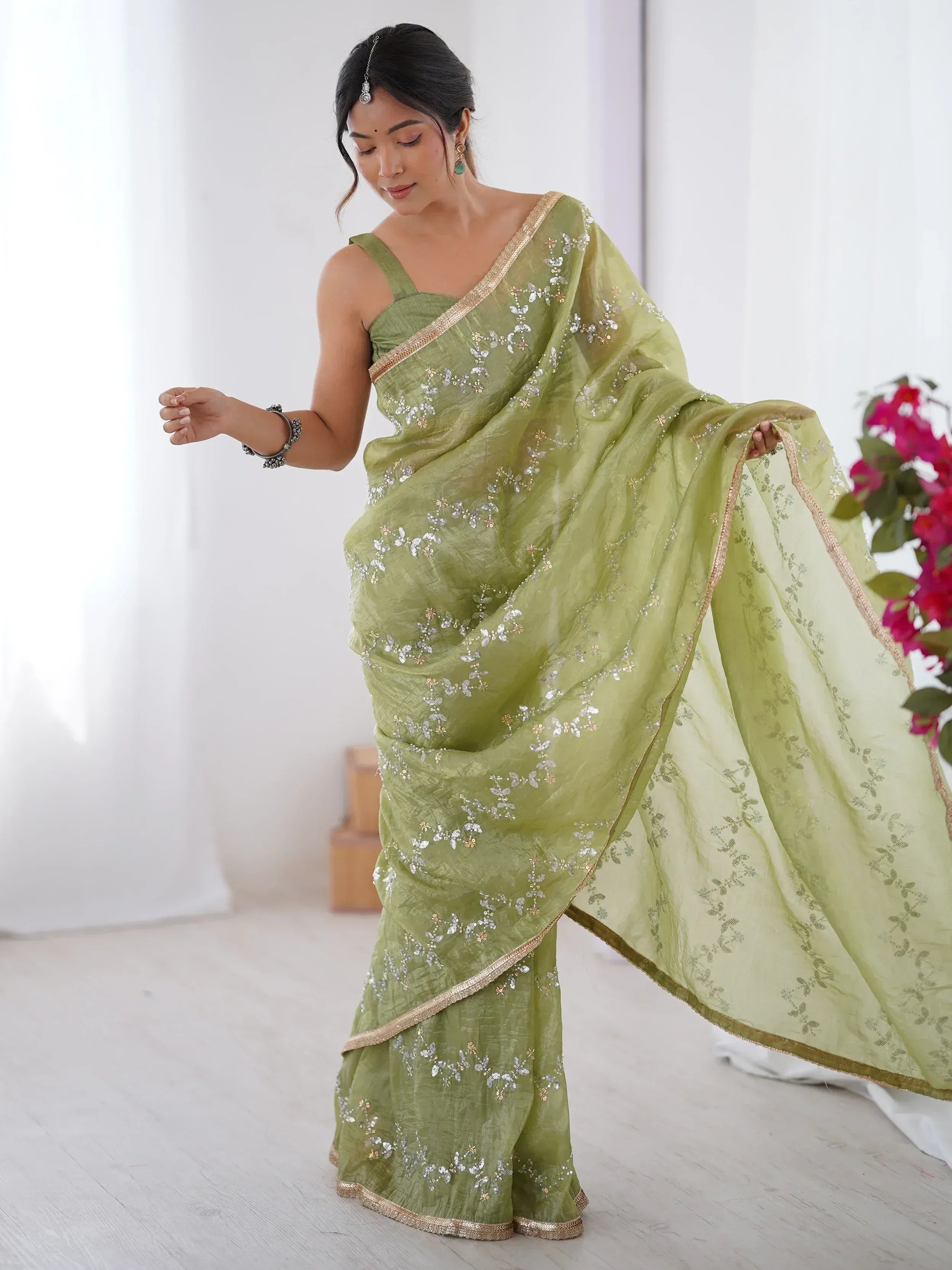Woman in olive green embroidered saree with gold border, ethnic Indian wear for festive occasions