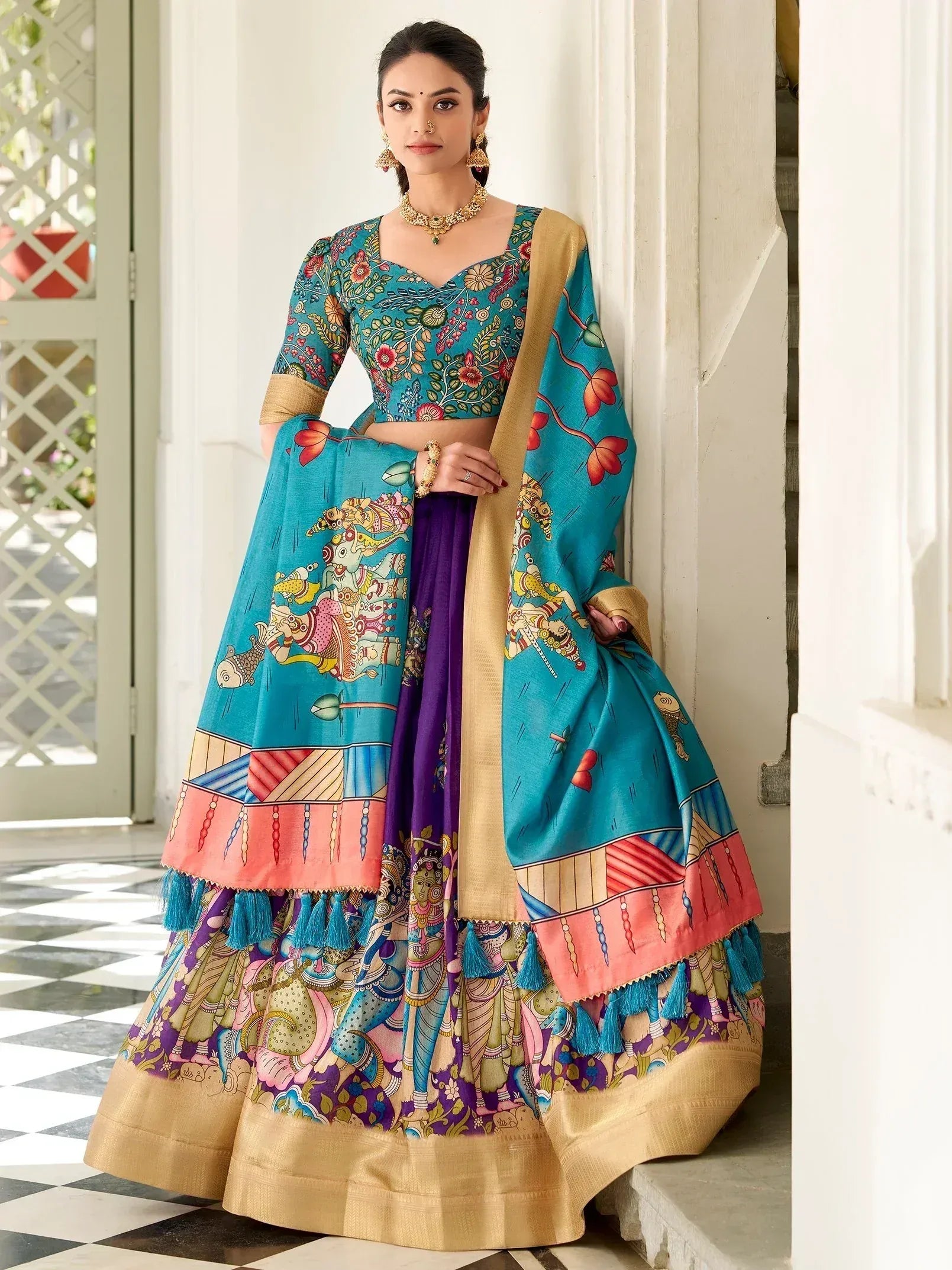 Vibrant teal and purple printed lehenga choli with gold border, tassels, and traditional Indian motifs for festive occasions