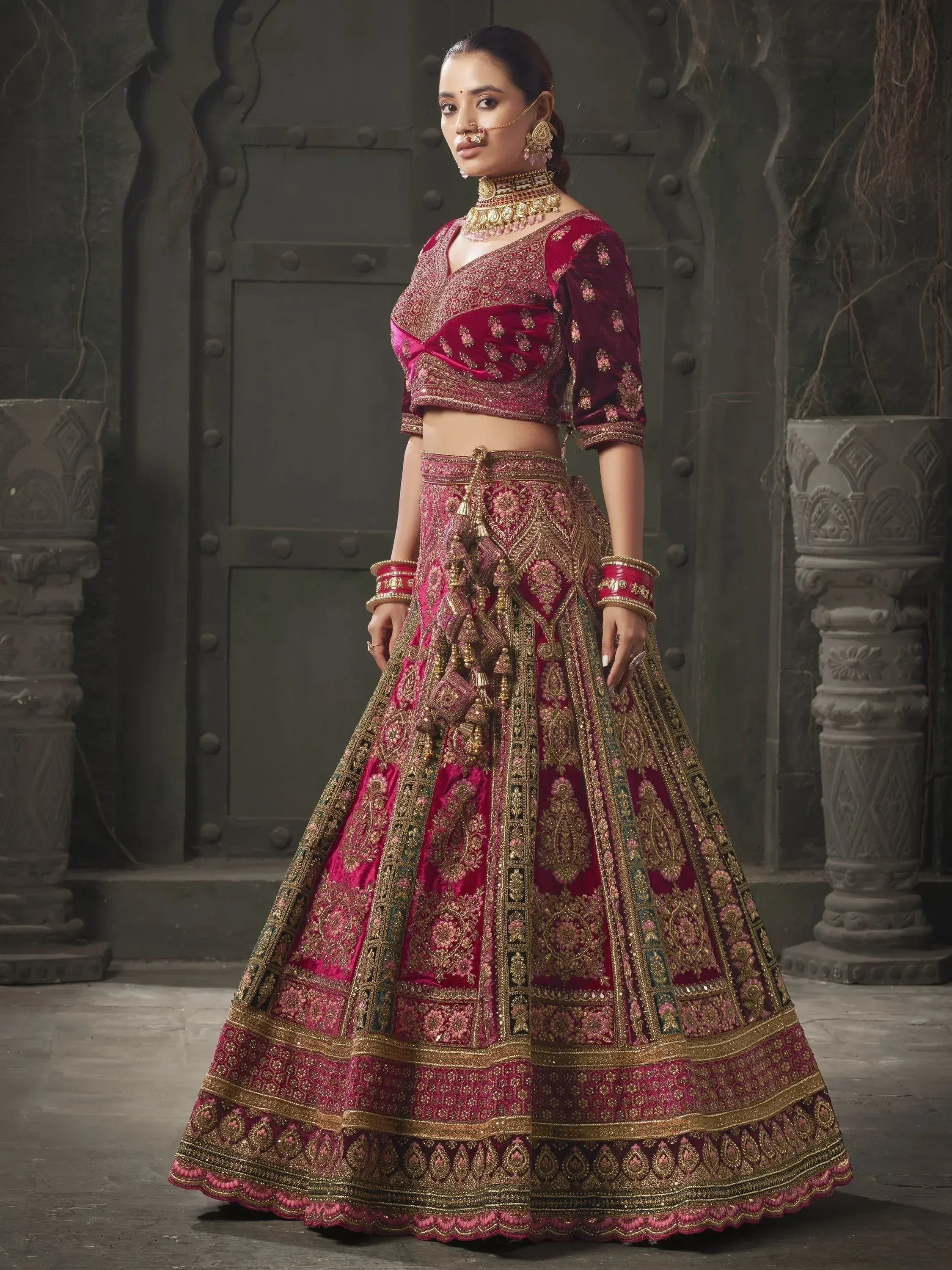 Elegant maroon velvet lehenga choli with gold embroidery, perfect for Indian weddings and festive occasions.