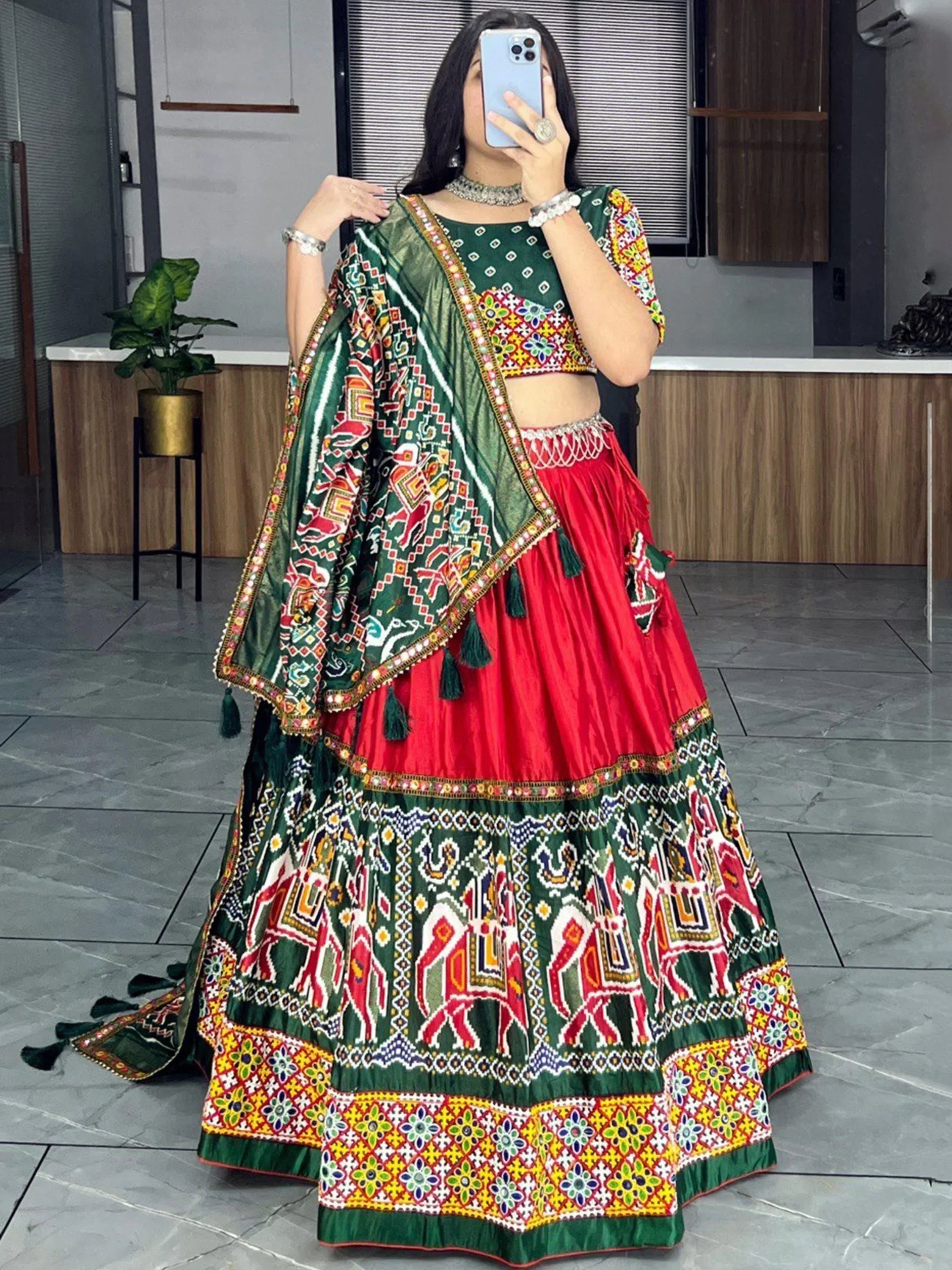 Vibrant green and red embroidered lehenga choli with mirror work and tassels, perfect for Indian ethnic wear.