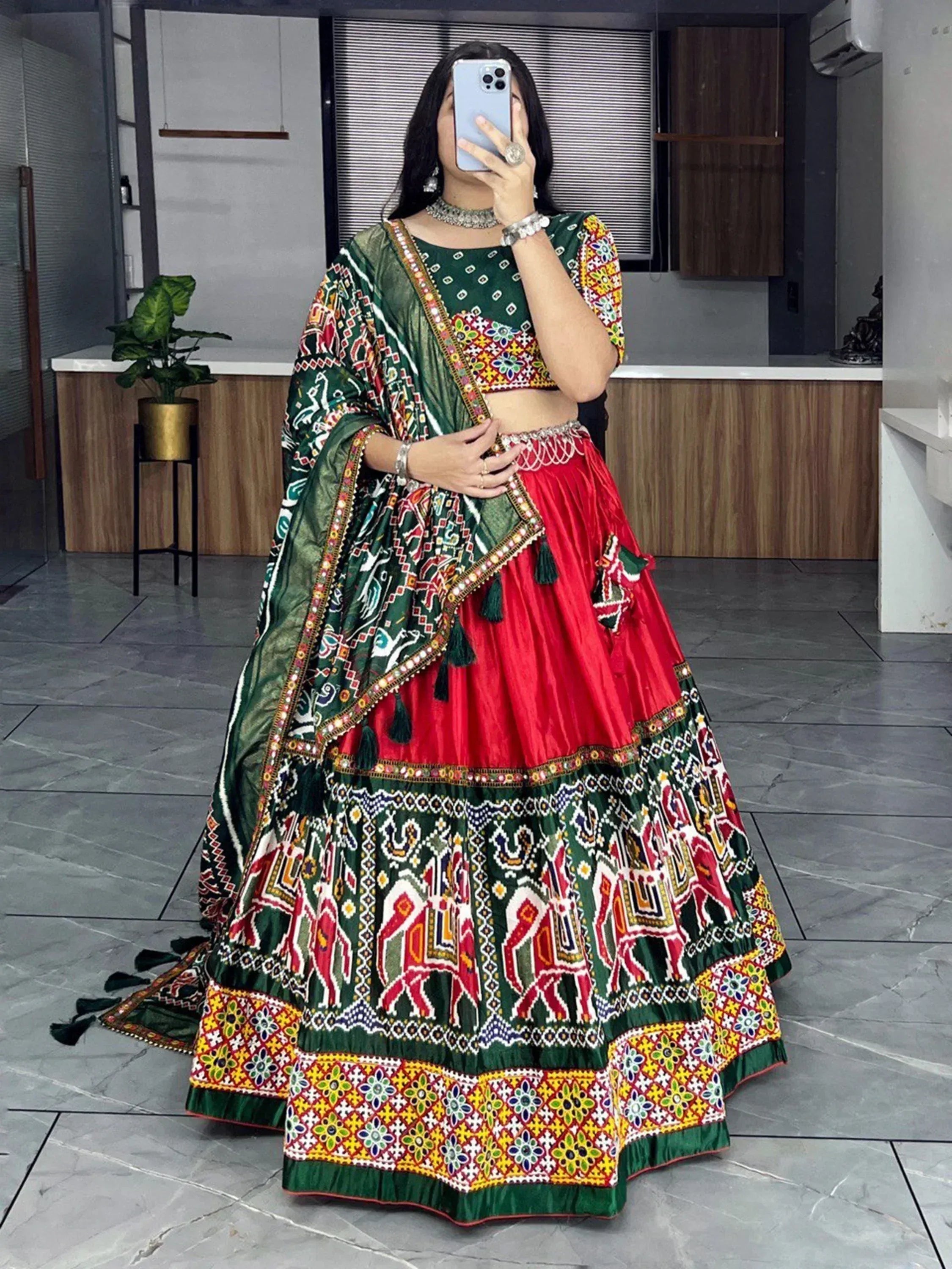 Vibrant green and red ethnic lehenga choli with mirror work and elephant motifs, perfect for Indian celebrations.