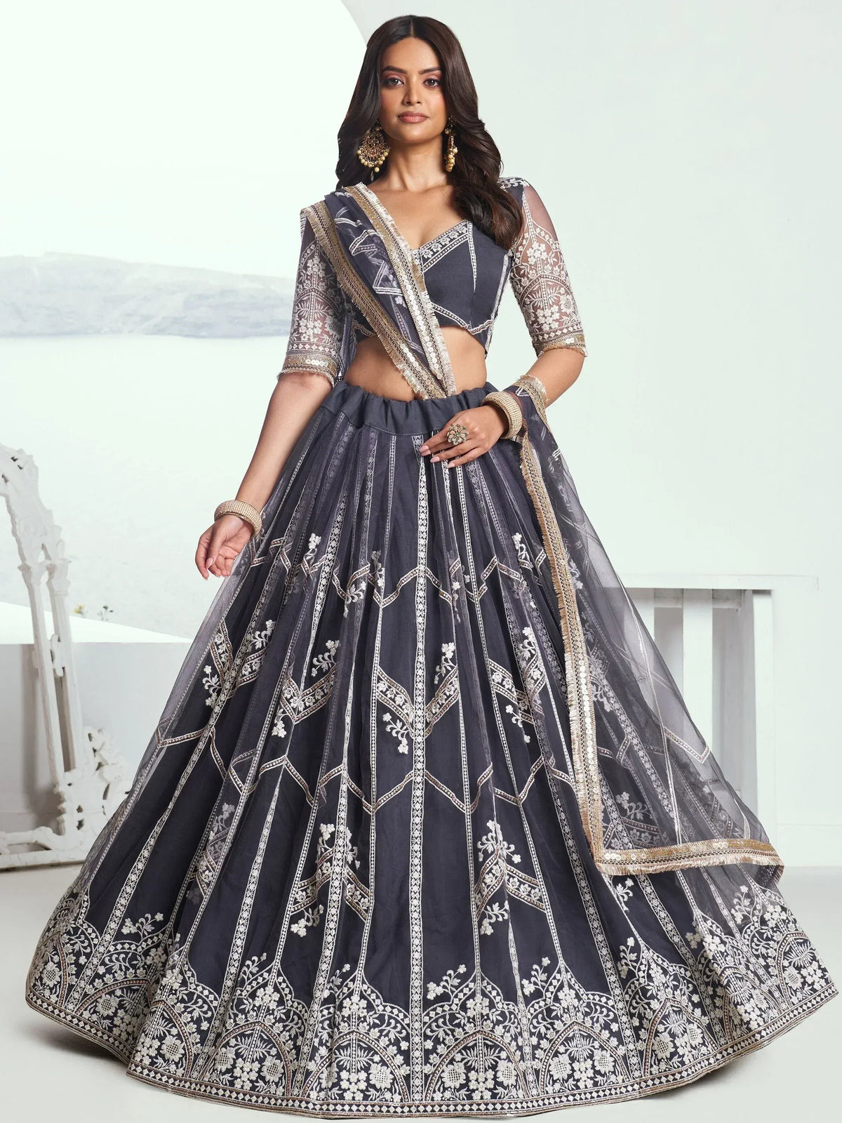 Grey embroidered lehenga choli with sheer sleeves and gold detailing, perfect for Indian ethnic wear occasions.