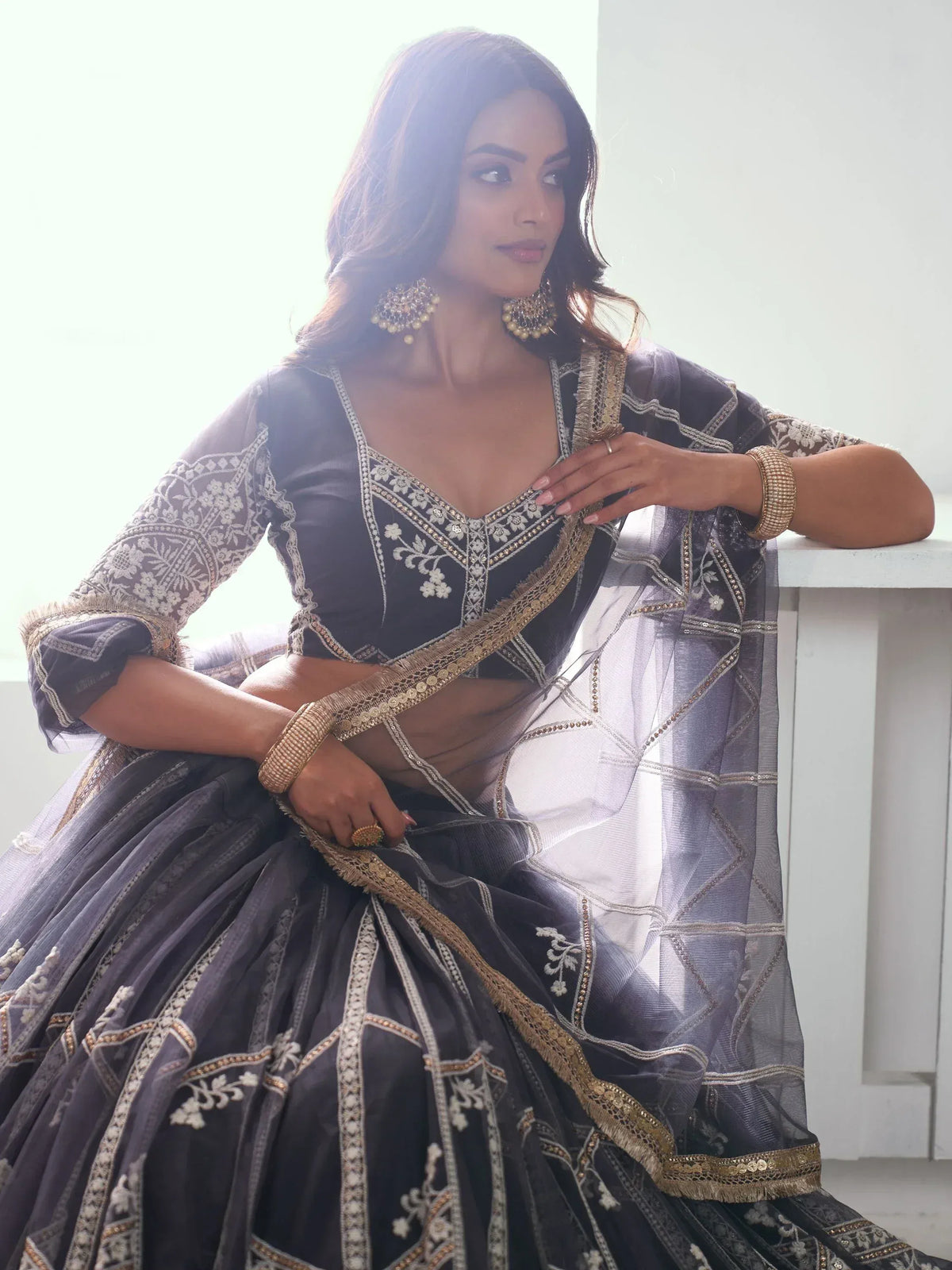 Elegant dark grey lehenga choli with gold embroidery, perfect for Indian ethnic wear events.