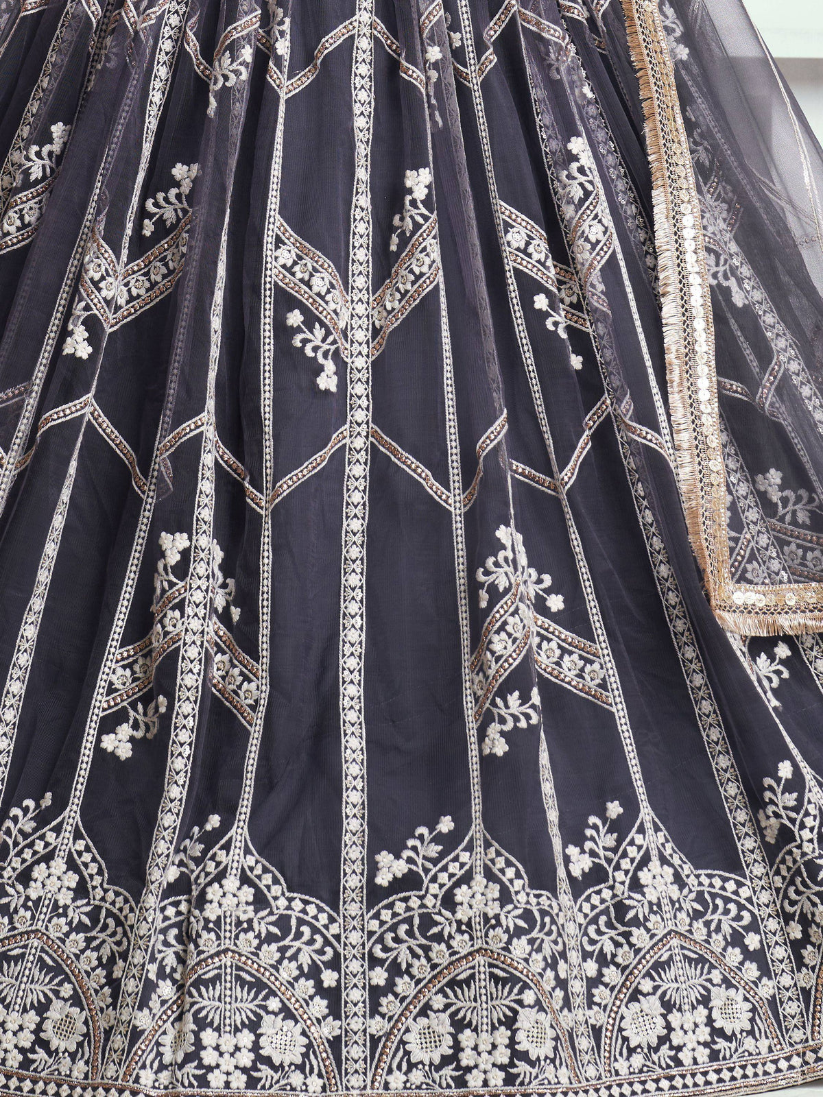 Dark grey lehenga with intricate white and gold floral embroidery, perfect for Indian ethnic wear.