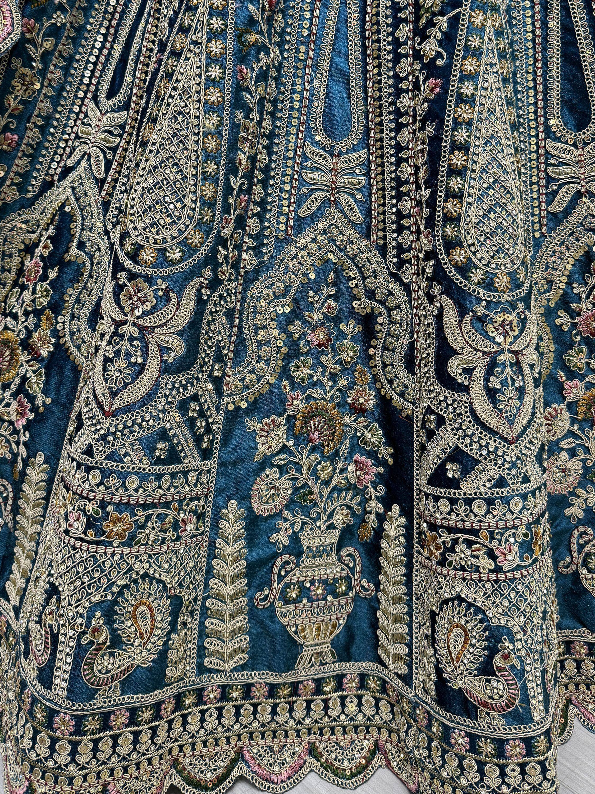 Luxury blue velvet lehenga with intricate gold embroidery, floral motifs, and sequin detailing for Indian ethnic wear