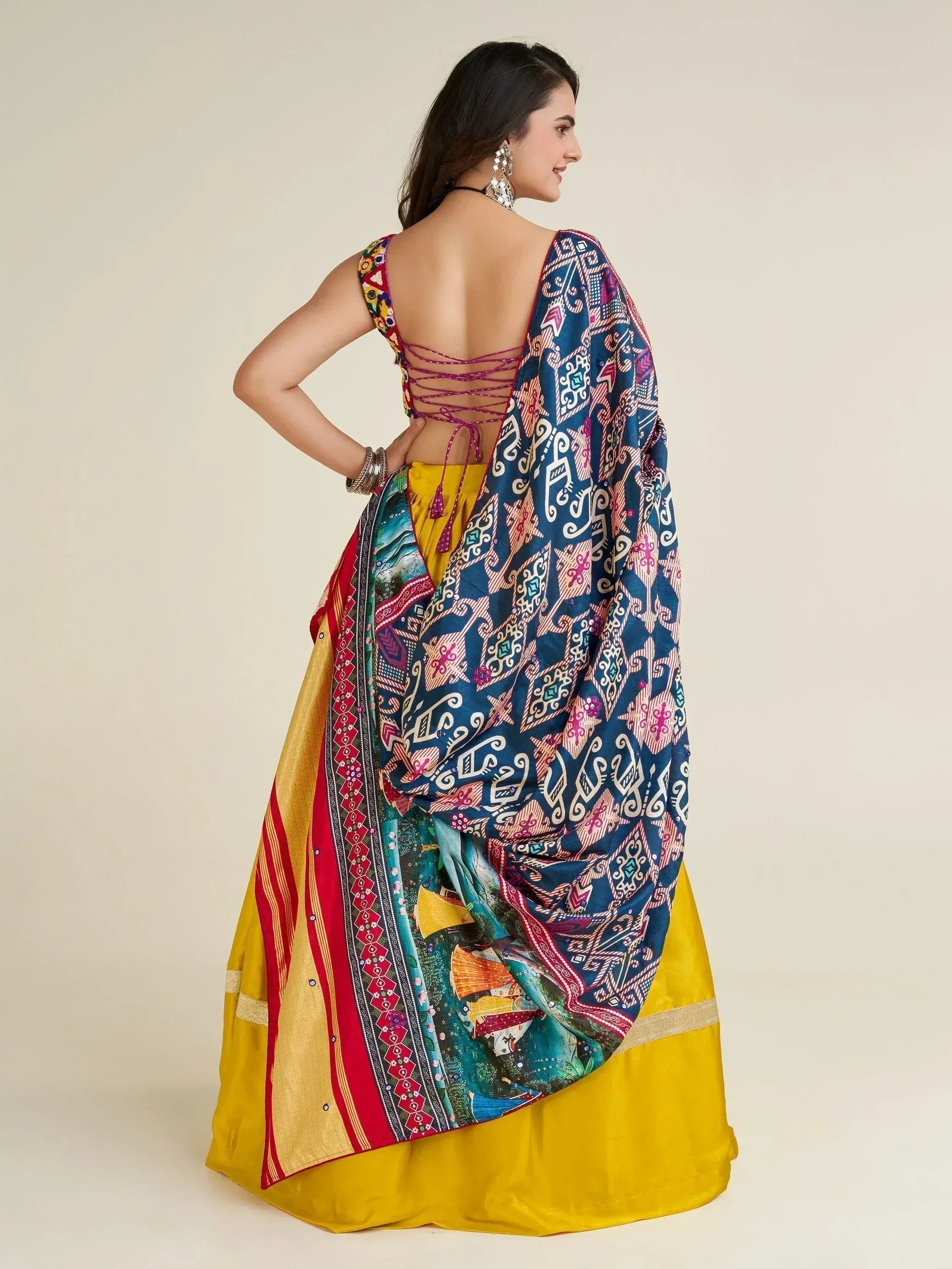 Woman in vibrant yellow lehenga with colorful printed dupatta and backless blouse, ethnic Indian wear