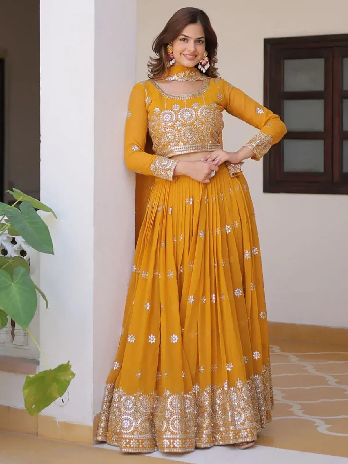 Mustard yellow embroidered lehenga choli with floral motifs and mirror work, perfect for Indian ethnic occasions