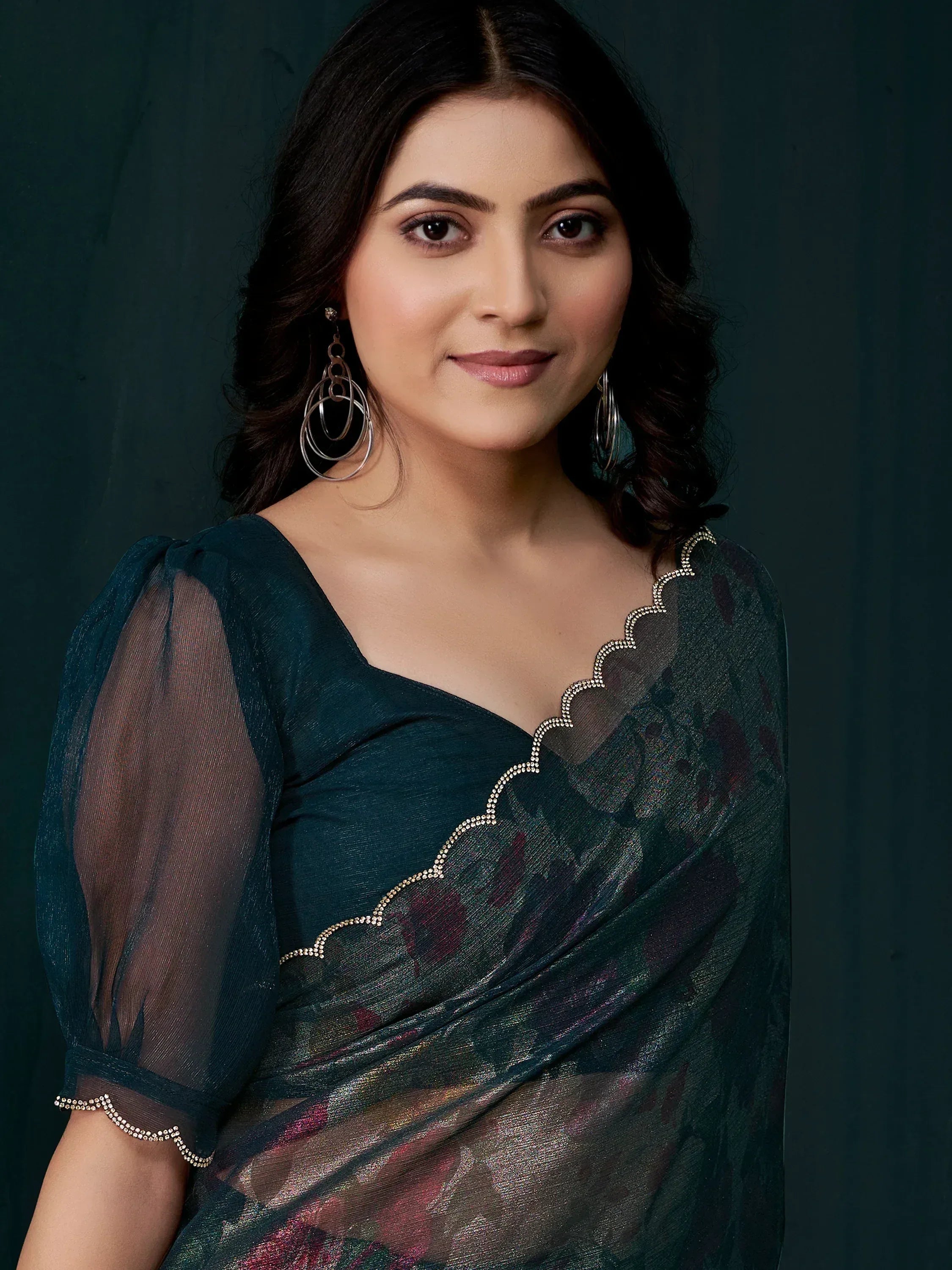 Woman in elegant dark green saree with sheer sleeves and scalloped beadwork, perfect for Indian ethnic occasions.