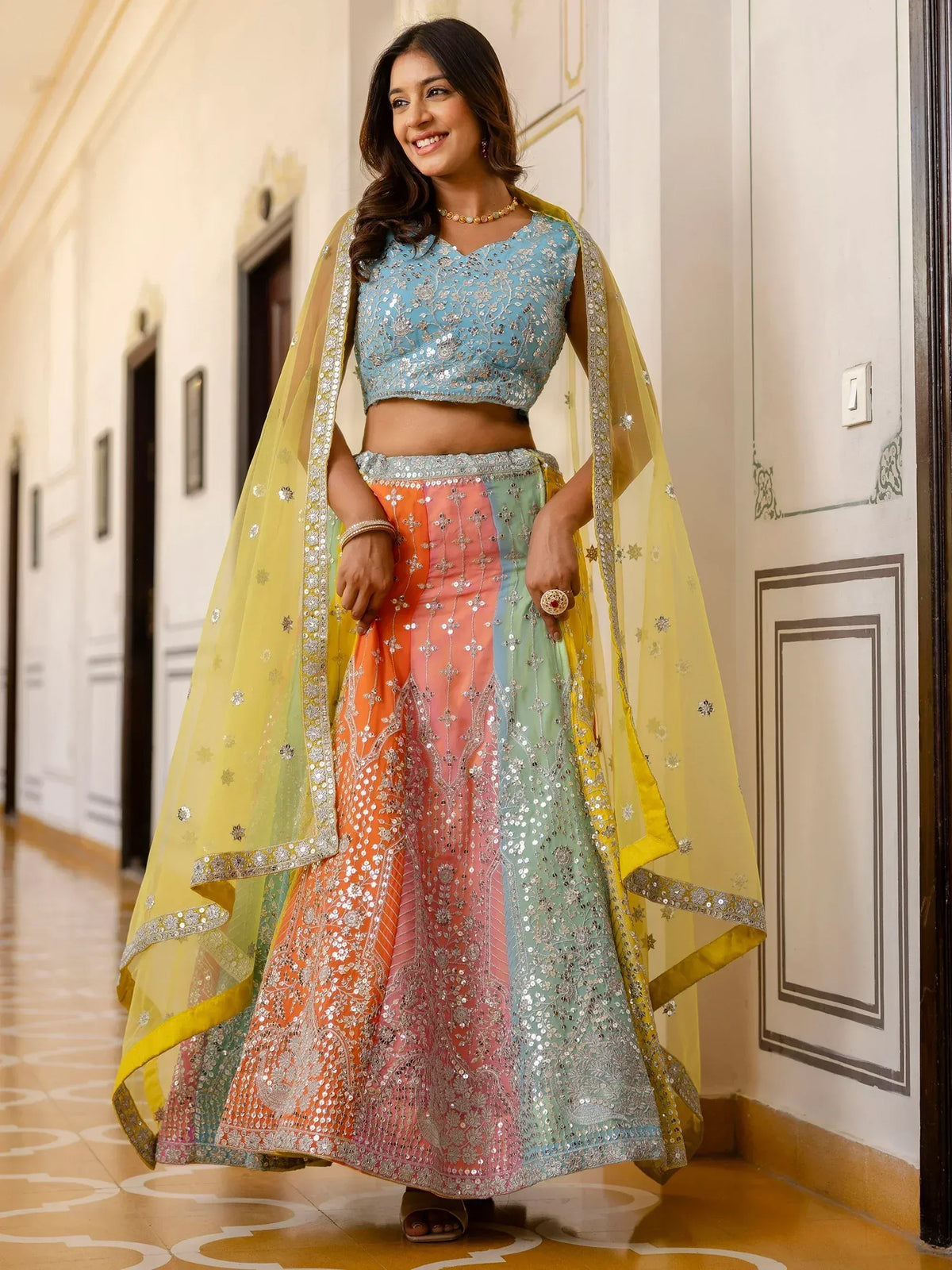 Woman in colorful embroidered lehenga choli with yellow dupatta, Indian ethnic wear for festive occasions