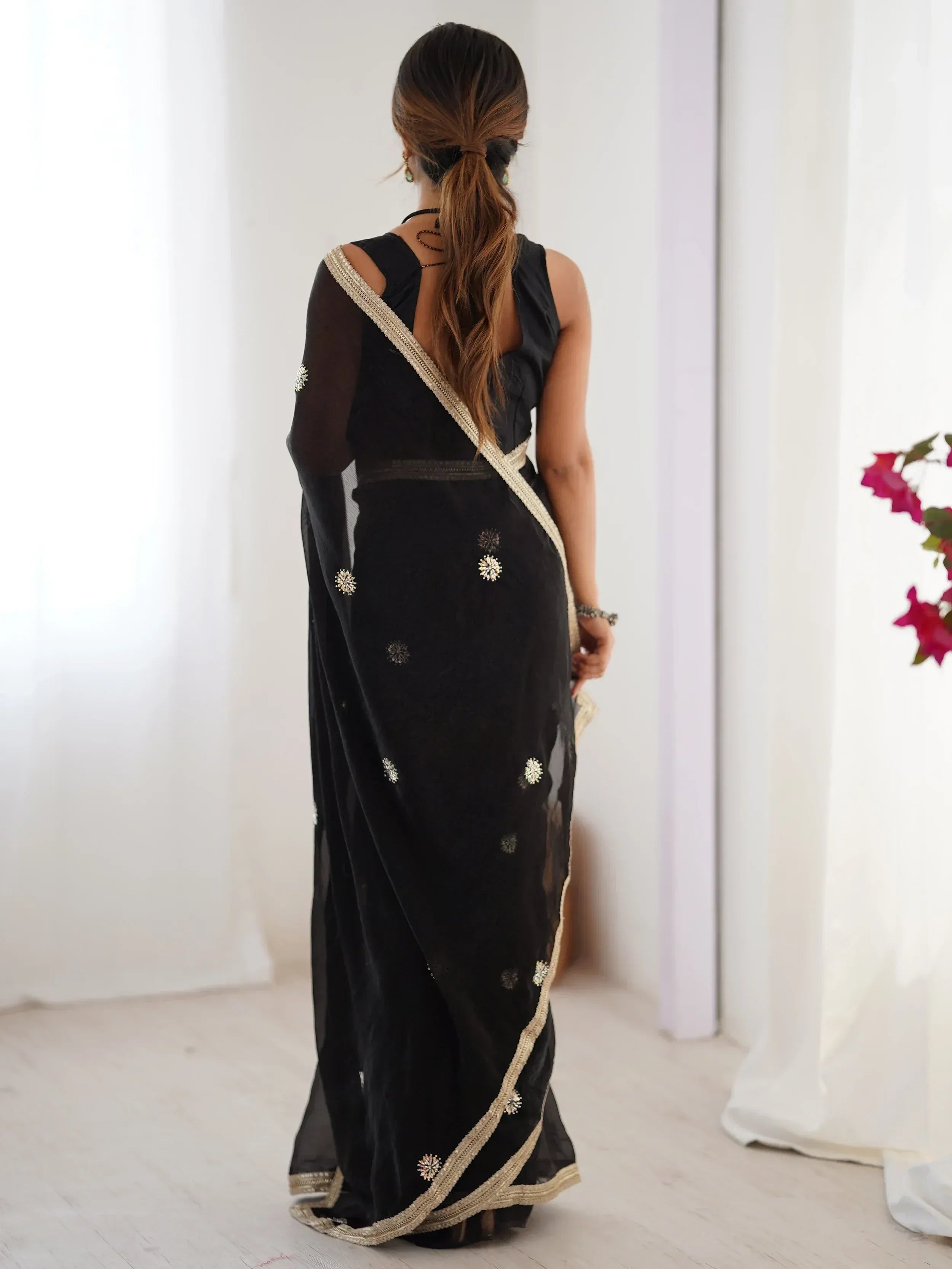 Black velvet saree with gold embroidery and sheer sleeves, back view