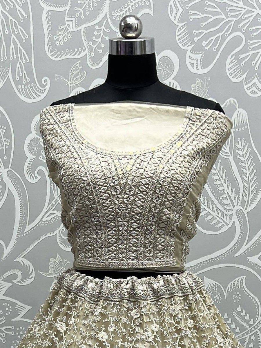 Elegant ivory lehenga choli with intricate silver embroidery, perfect for Indian weddings and festive occasions.