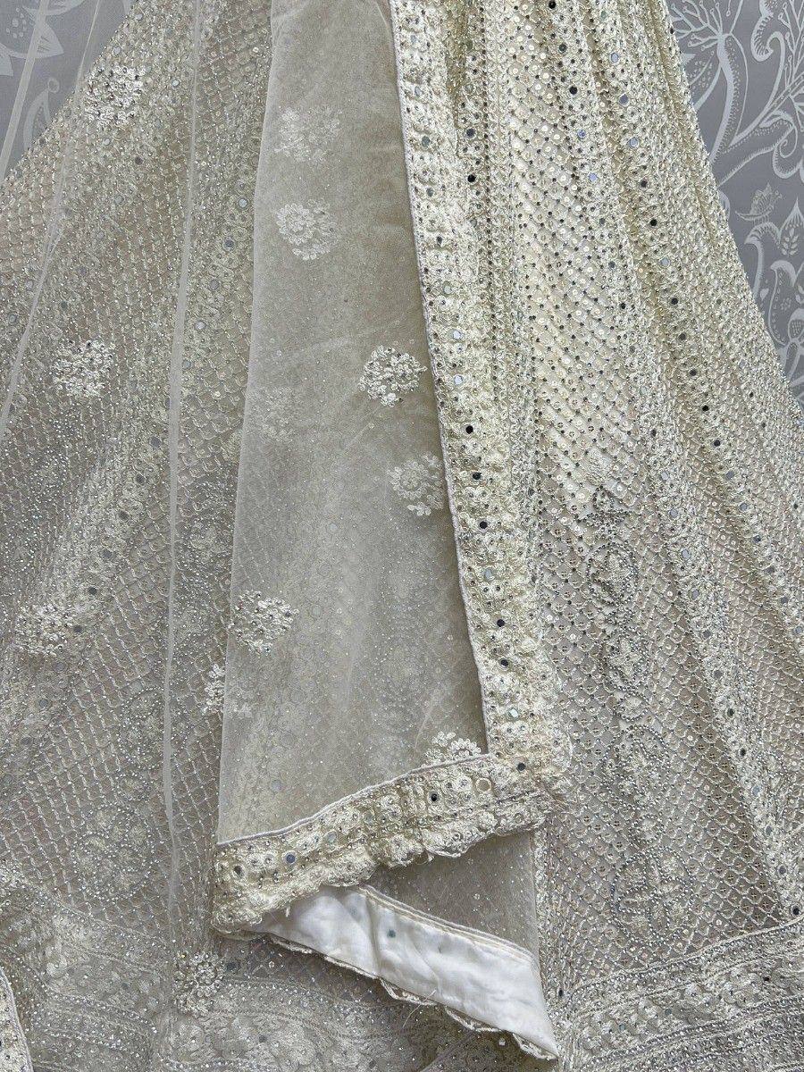 Elegant ivory lehenga with intricate sequin and embroidery detailing, perfect for Indian weddings and festive occasions.