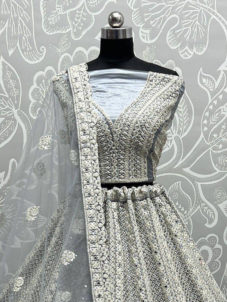 Elegant silver designer lehenga choli with intricate embroidery and sheer dupatta, perfect for weddings and festivals.