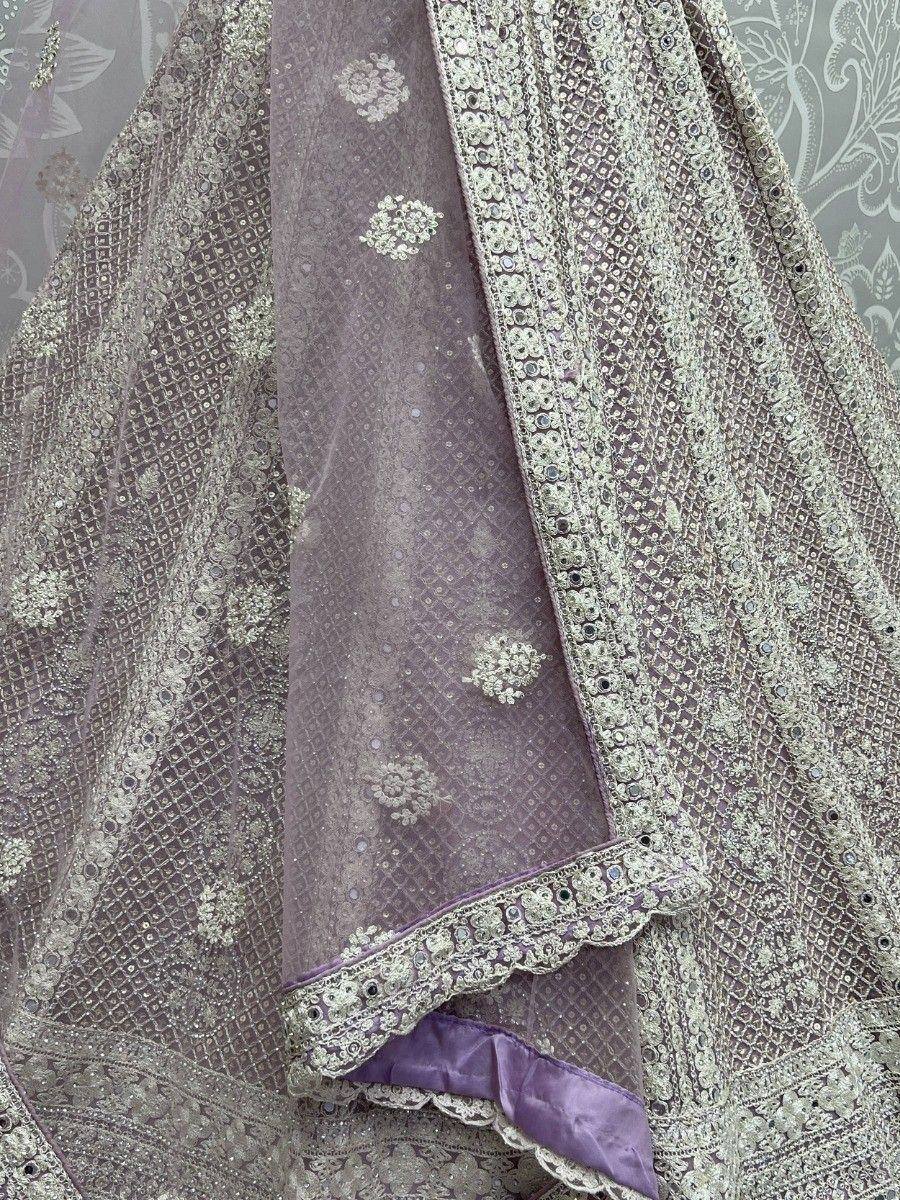 Elegant purple lehenga choli with intricate gold embroidery and mirror work, perfect for Indian ethnic wear.