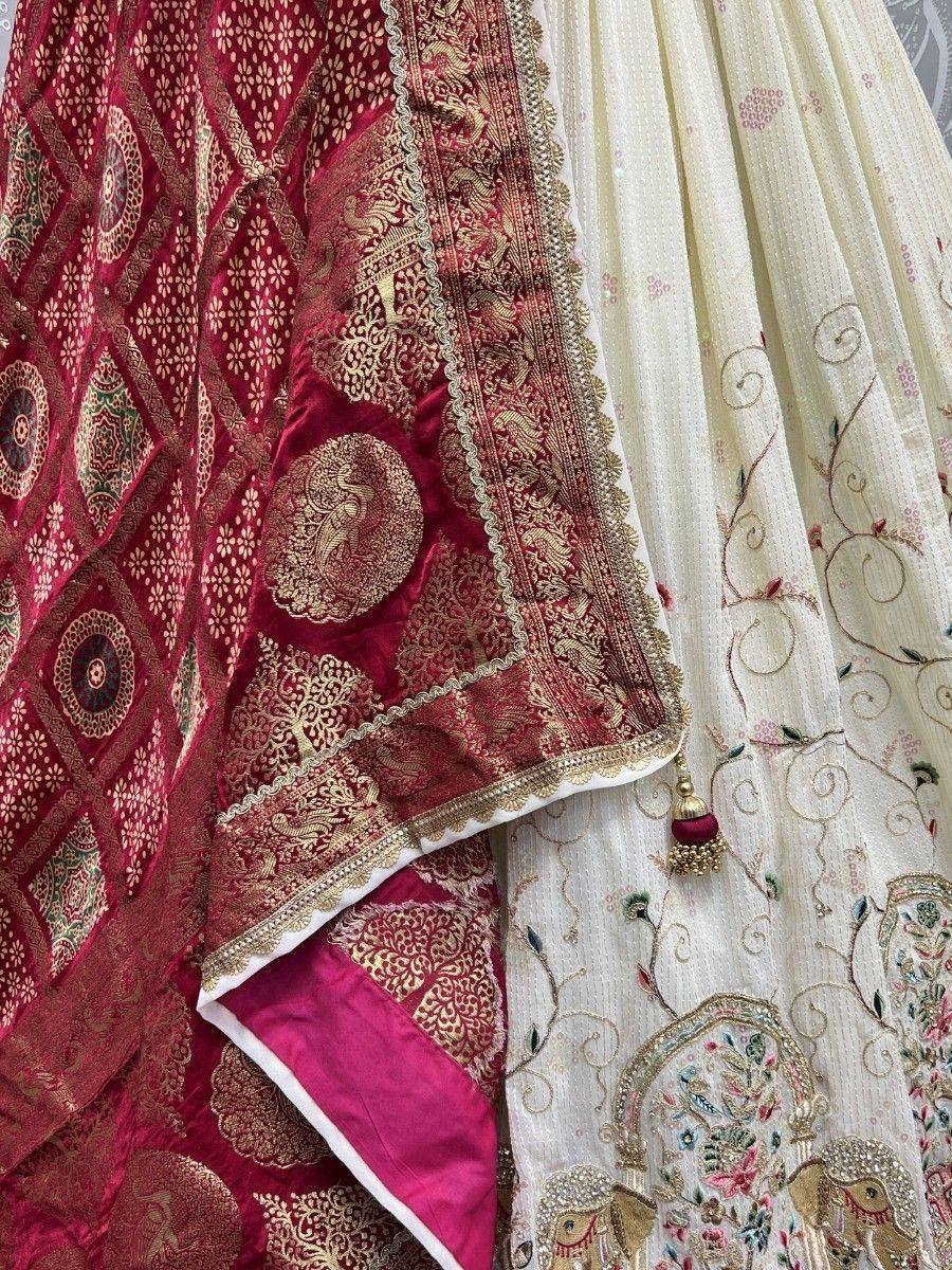 Elegant Indian ethnic wear with intricate gold embroidery and floral patterns on red and cream fabric.