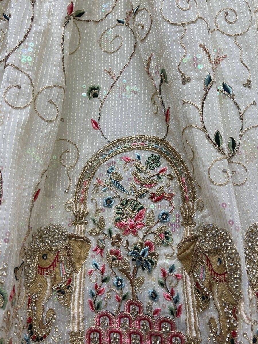 White ethnic lehenga with floral embroidery, sequins, and elephant motifs for Indian weddings