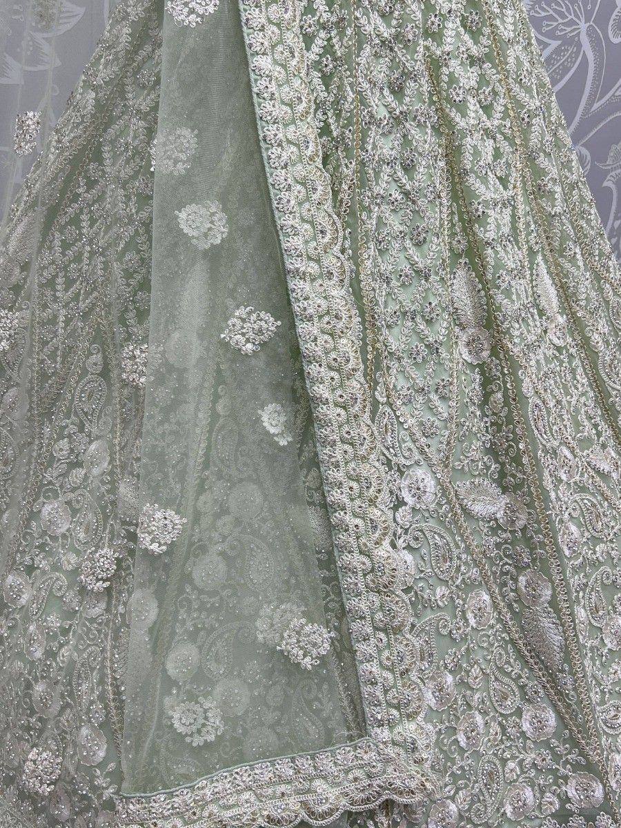 Mint green designer lehenga choli with intricate silver embroidery and floral motifs, perfect for weddings.