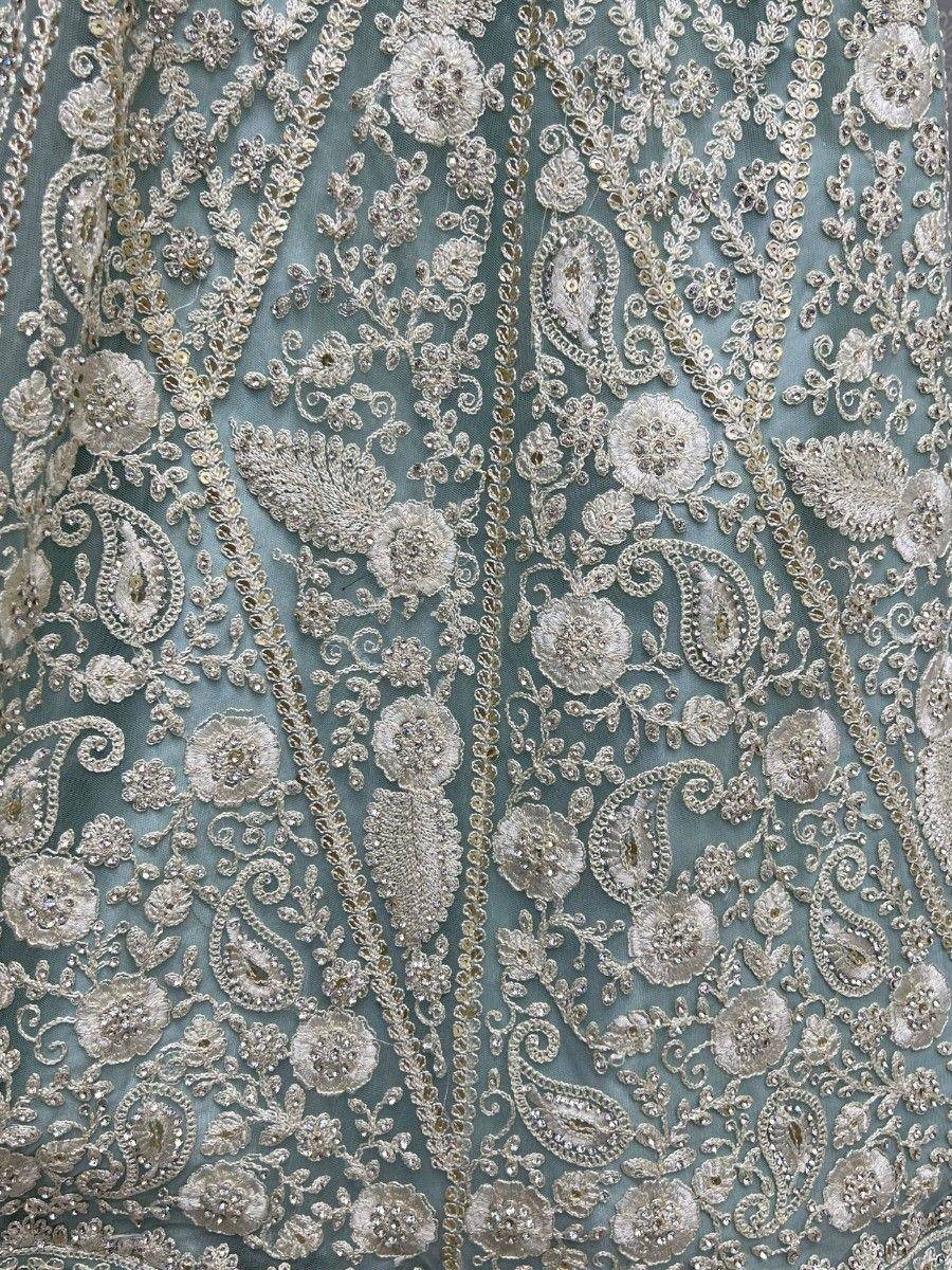 Teal designer lehenga with intricate silver floral and paisley embroidery, perfect for Indian ethnic wear.