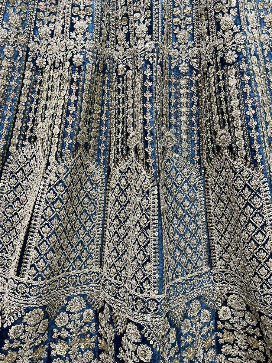 Blue velvet lehenga with intricate gold embroidery and sequin detailing, perfect for Indian ethnic wear.