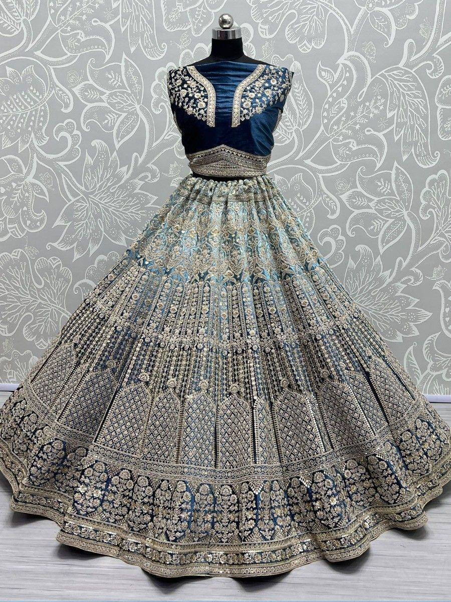 Blue designer lehenga choli with heavy gold embroidery, perfect for Indian weddings and festive occasions.