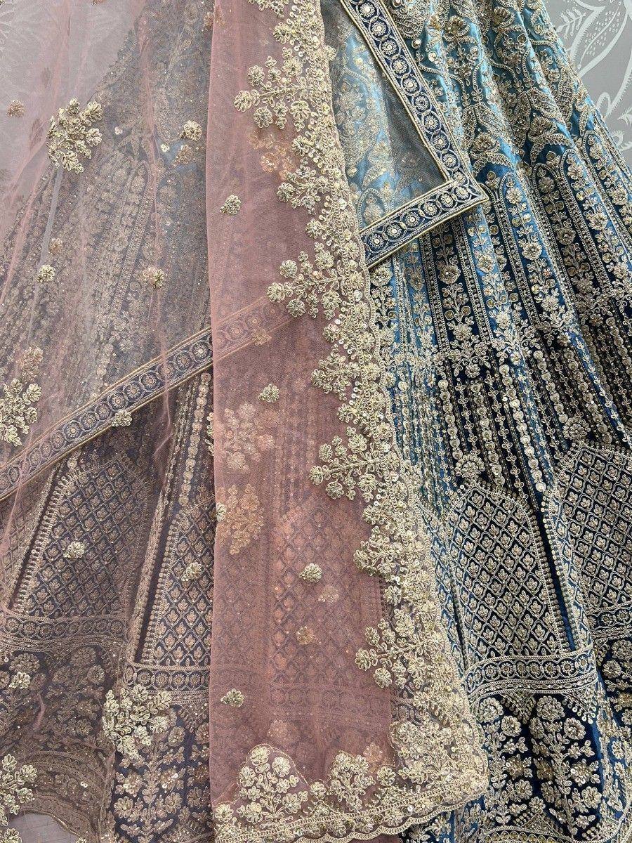 Designer lehenga choli with intricate gold embroidery and sheer dupatta, perfect for Indian weddings and festive occasions.