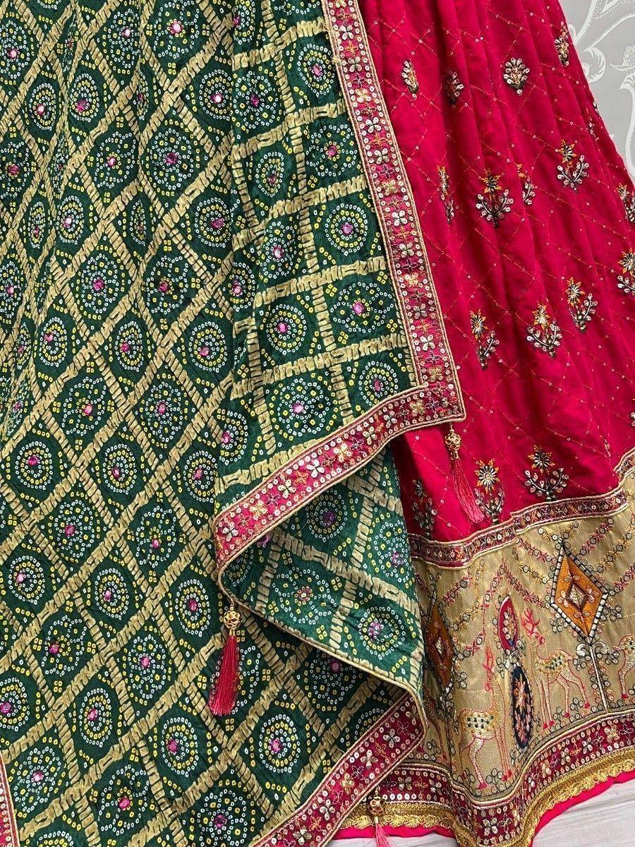 Green and red ethnic lehenga choli with intricate gold embroidery and mirror work, perfect for Indian weddings.