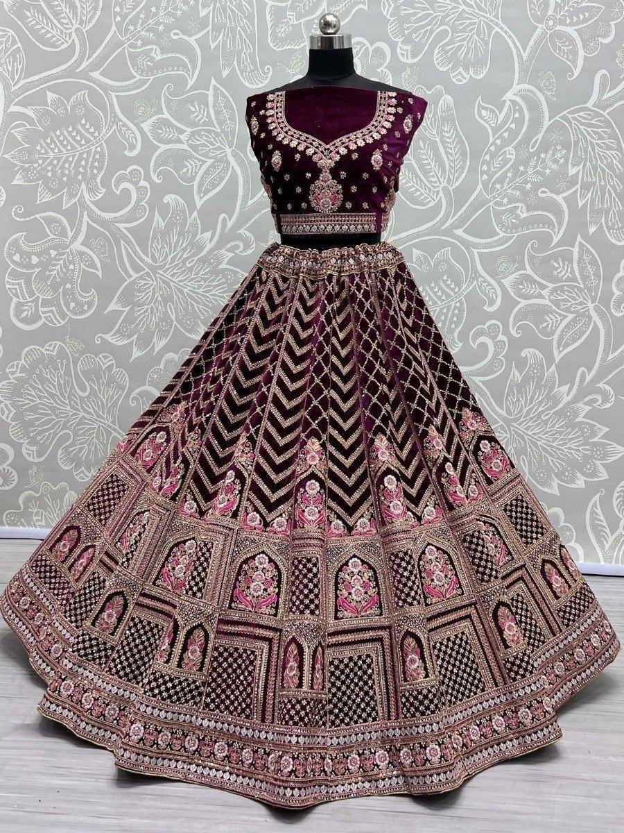 Luxury maroon velvet lehenga choli with intricate gold and pink embroidery, perfect for Indian weddings and festive occasions.