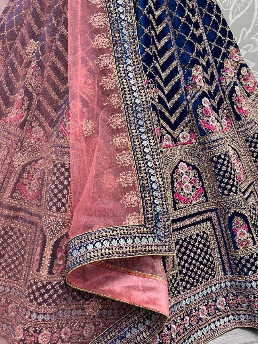 Luxury navy blue velvet lehenga with pink floral embroidery and sheer dupatta, perfect for Indian weddings.
