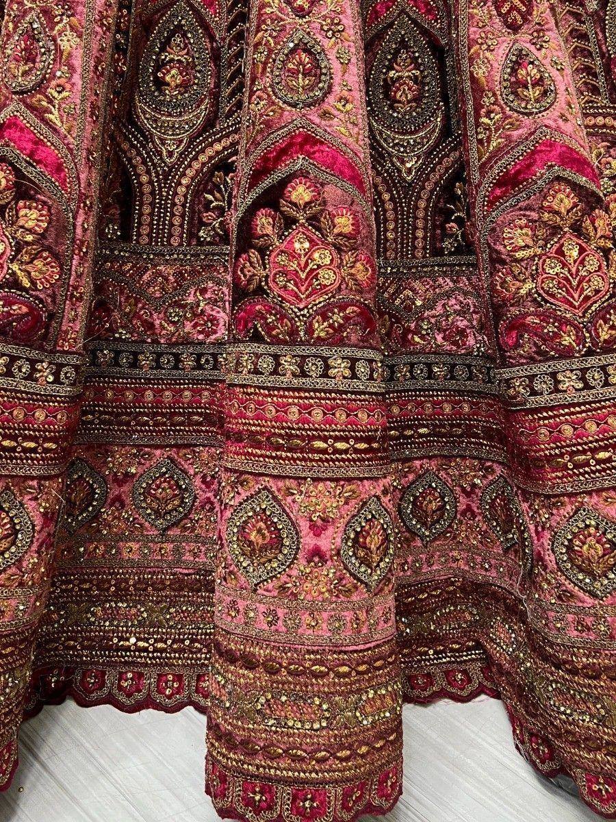 Richly embroidered pink and gold Indian lehenga with intricate floral and paisley motifs, perfect for weddings.