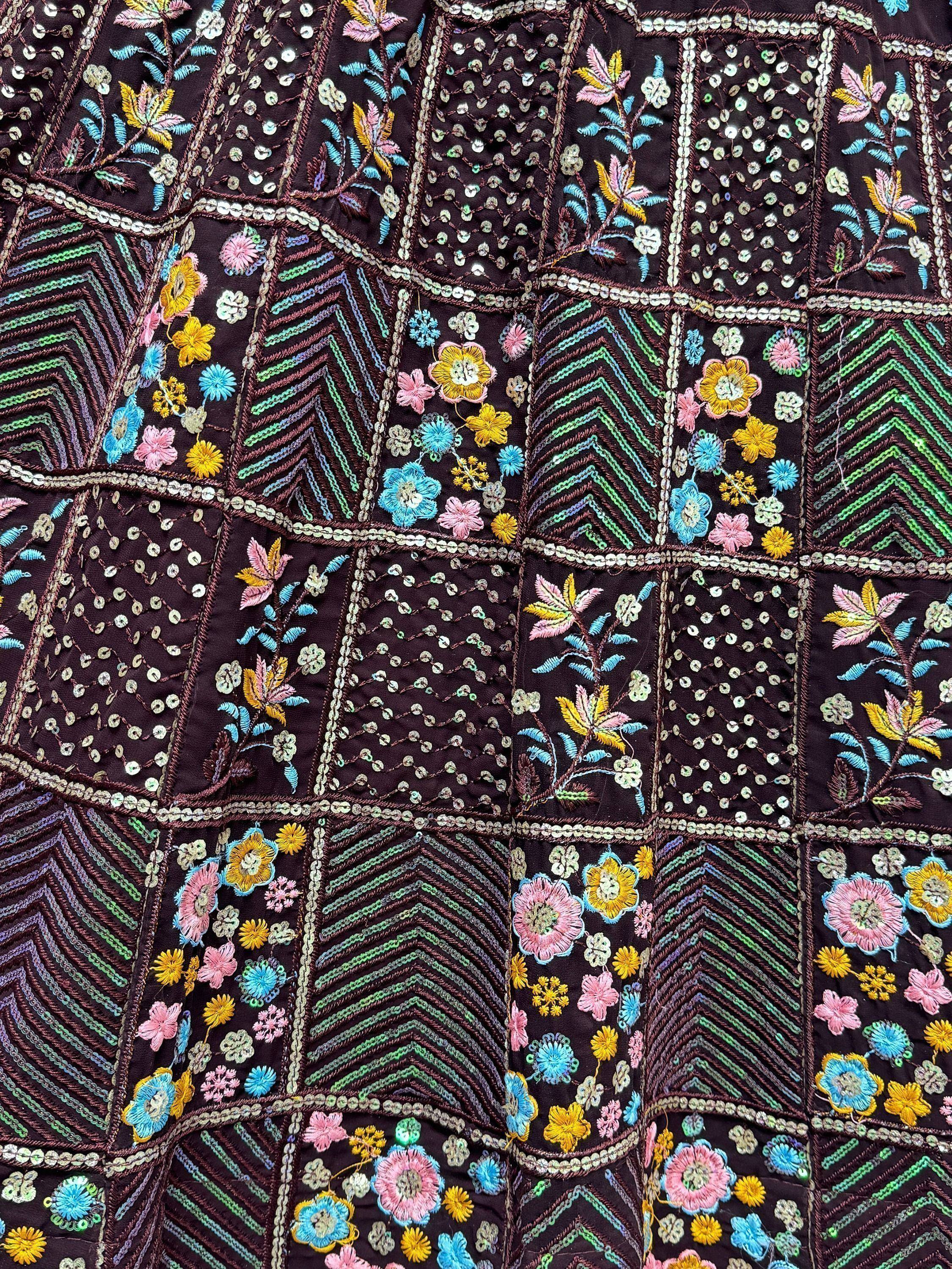 Dark purple ethnic wear with vibrant floral embroidery and sequin detailing, perfect for Indian occasions.