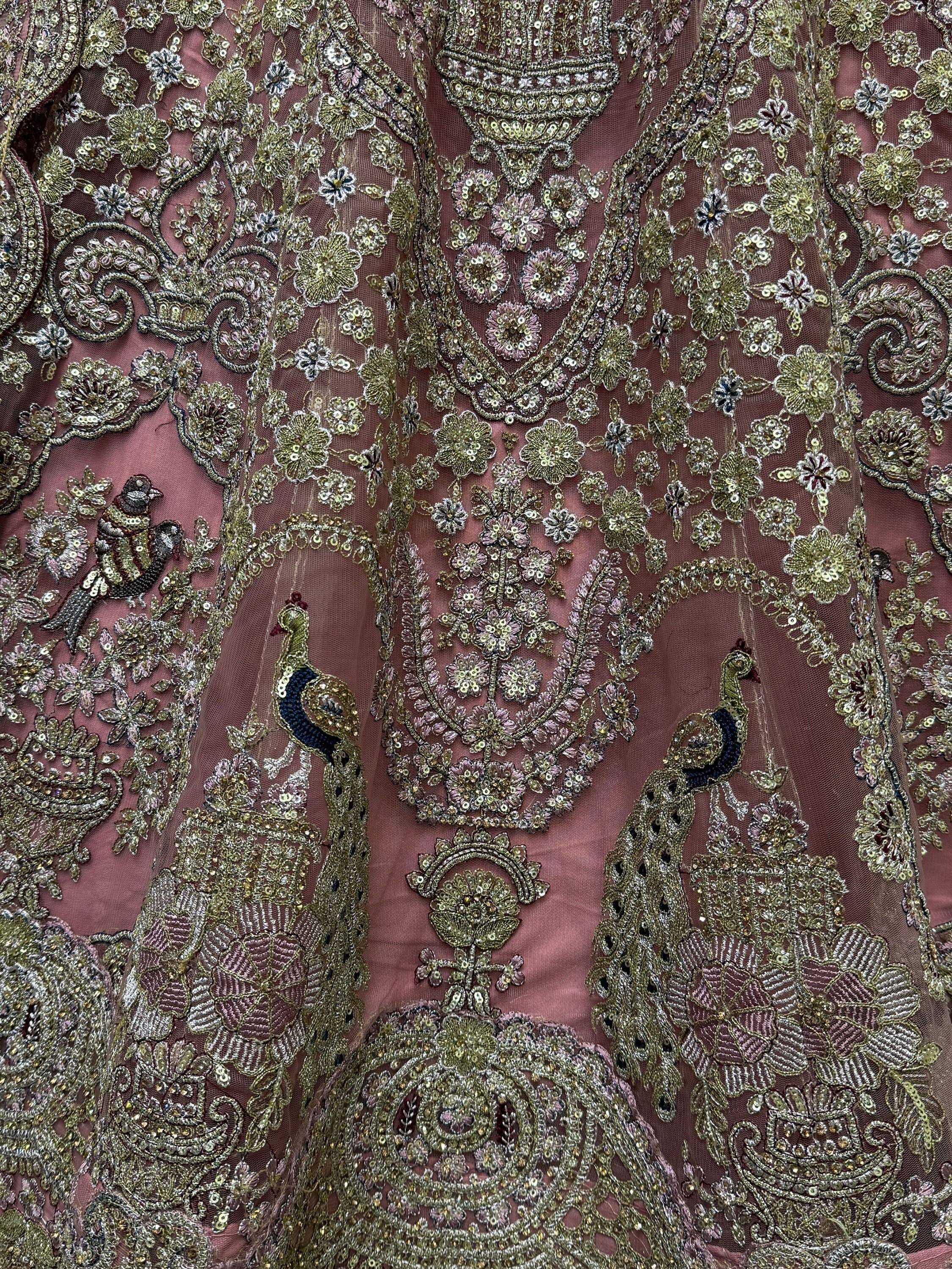 Luxury Indian ethnic wear with intricate peacock and floral embroidery on dusty rose fabric, perfect for weddings.