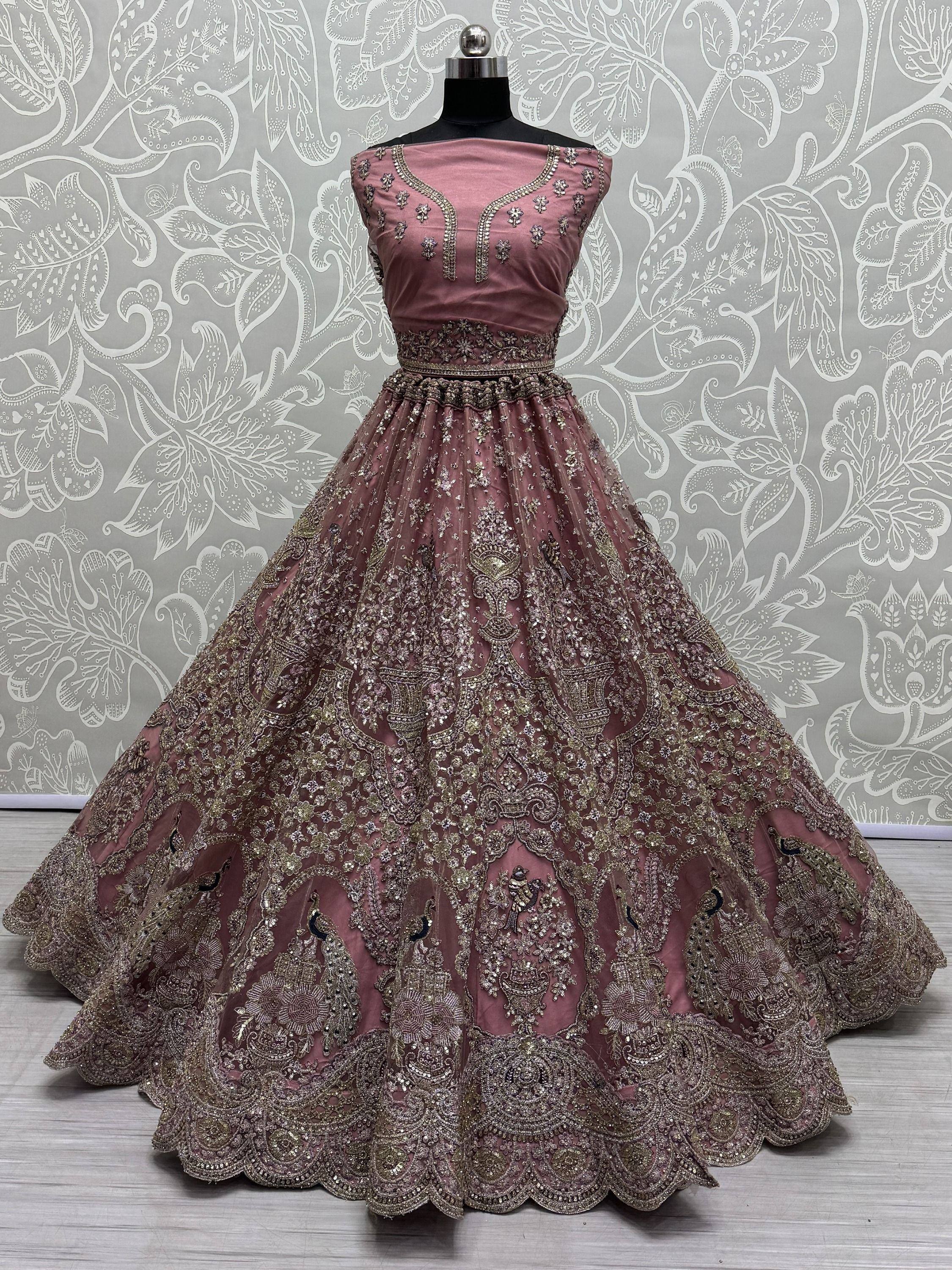 Dusty pink designer lehenga choli with heavy gold embroidery and peacock motifs, perfect for weddings
